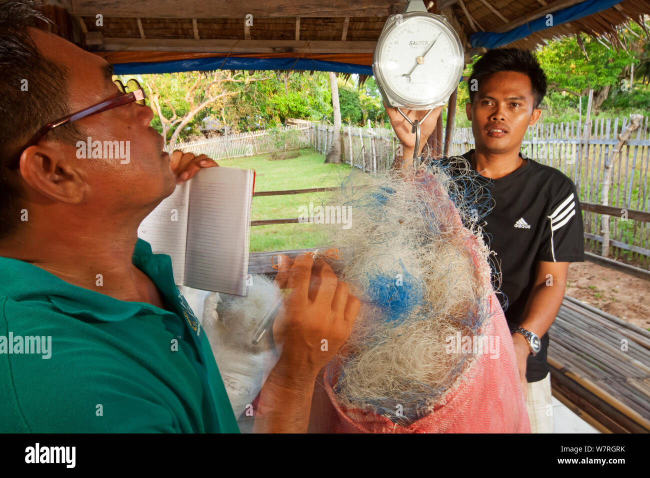 Project Seahorse Mitarbeiter der Stiftung wiegen verworfen Kunststoff Fischernetze gesammelt und bereit, für das Recycling in Teppich Material versandt werden, Jao Insel, Danajon Bank, Central Visayas, Philippinen, April 2013 Stockfoto