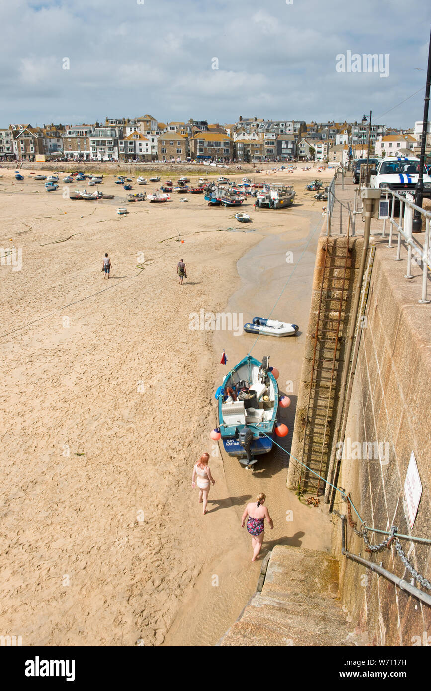 Angeln Boot günstig neben dem Leiter der Hafenmauer und Pier. St Ives, Cornwall, England, Vereinigtes Königreich Stockfoto