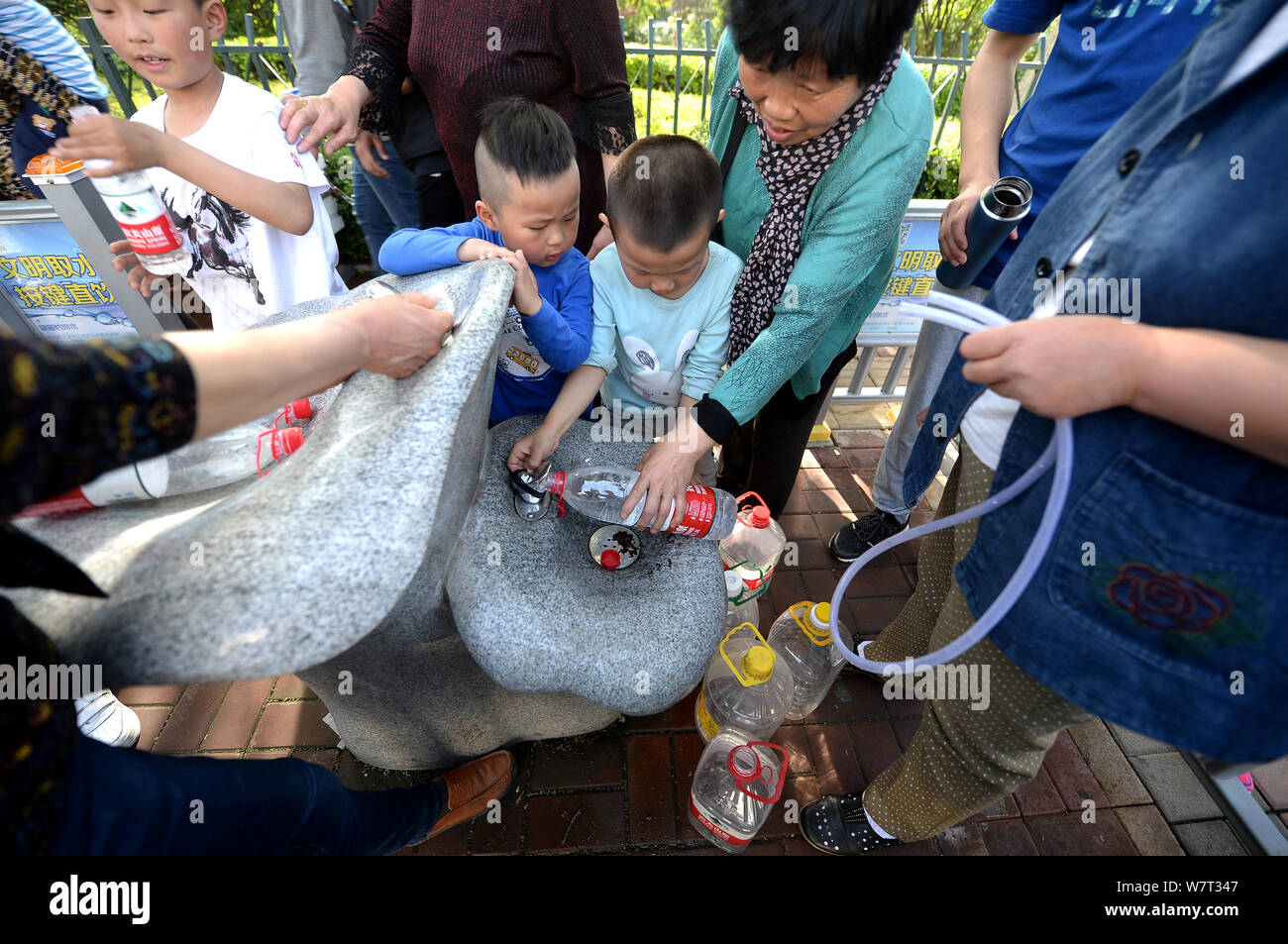 Touristen und Bewohner füllen ihre Flaschen Wasser aus einem Brunnen am Straßenrand in Ji'nan Stadt zu nehmen, der ostchinesischen Provinz Shandong, 29. April 201 Stockfoto