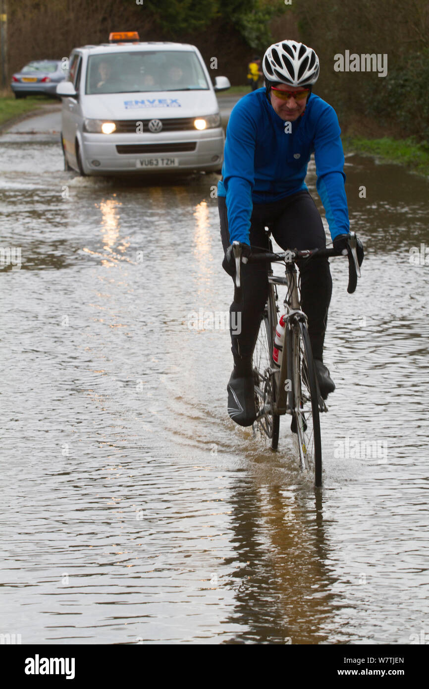 In Form von wasserdichter Kleidung radfahren Radfahrer durch Hochwasser Hochwasser im Februar 2014, Upton bei Severn, Worcestershire, England, UK, 9. Februar 2014. Stockfoto