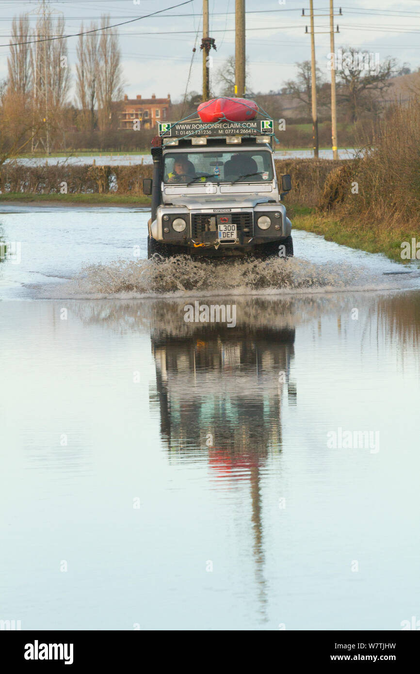 Landrover mit Kajak fahren durch Wasser während der Februar 2014 Überschwemmungen, Gloucestershire, England, UK, 7. Februar 2014. Stockfoto