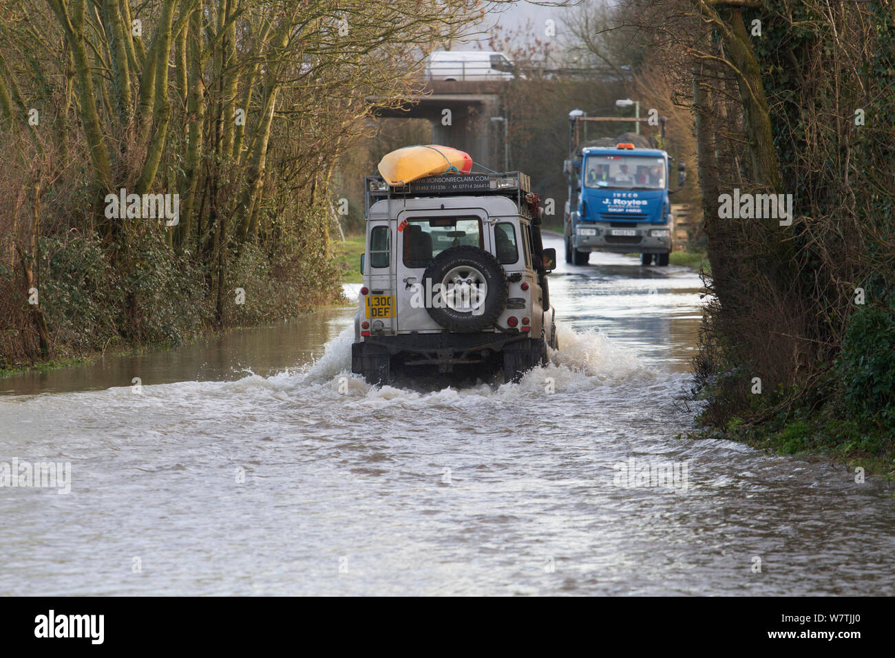 Landrover mit Kajak fahren durch Wasser während der Februar 2014 Überschwemmungen, Gloucestershire, England, UK, 7. Februar 2014. Stockfoto
