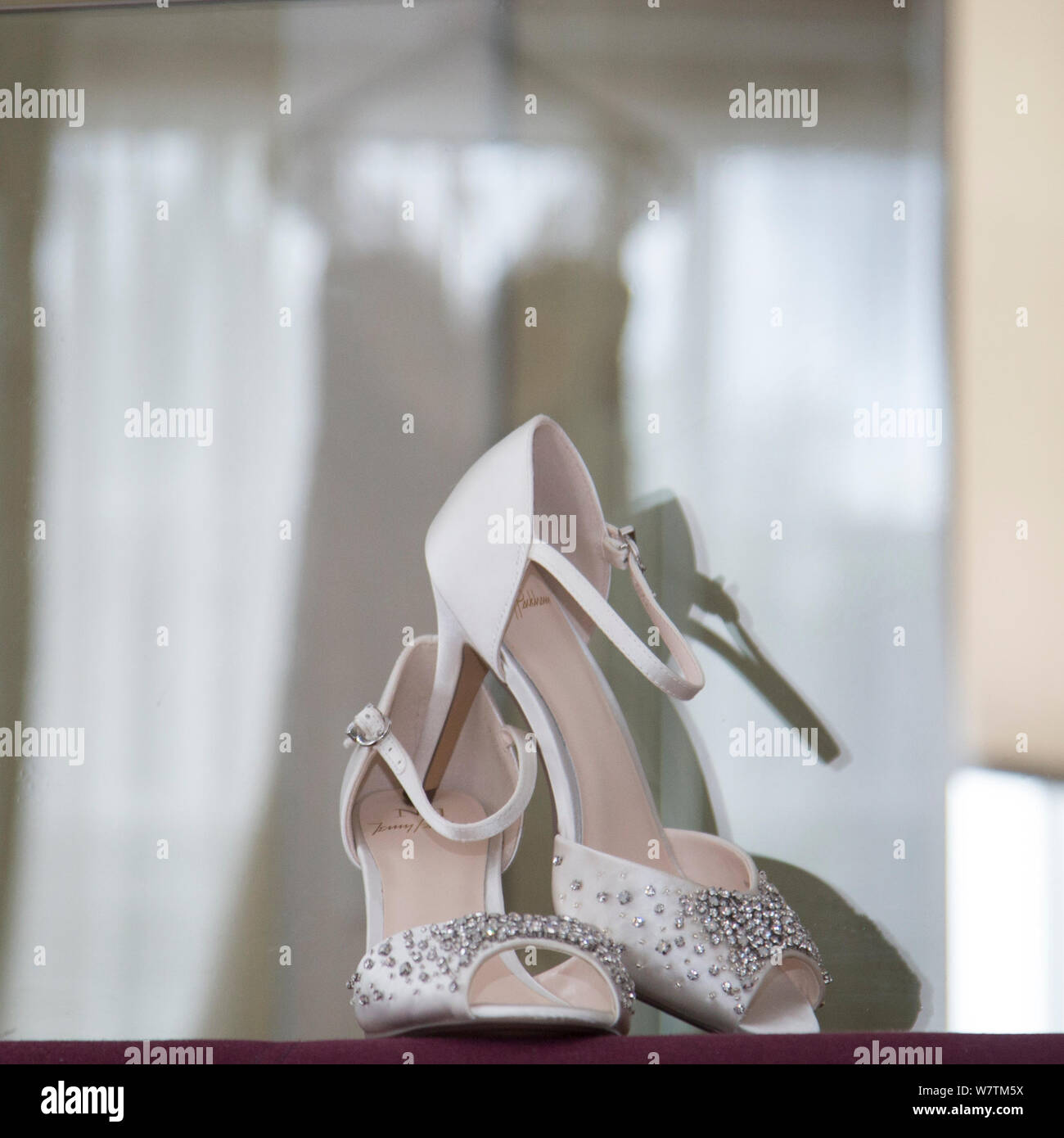 Bräute Schuhe mit Reflexion der Kleid im Hintergrund an Ihrem Hochzeitstag, Braut prep Fotografie Stockfoto