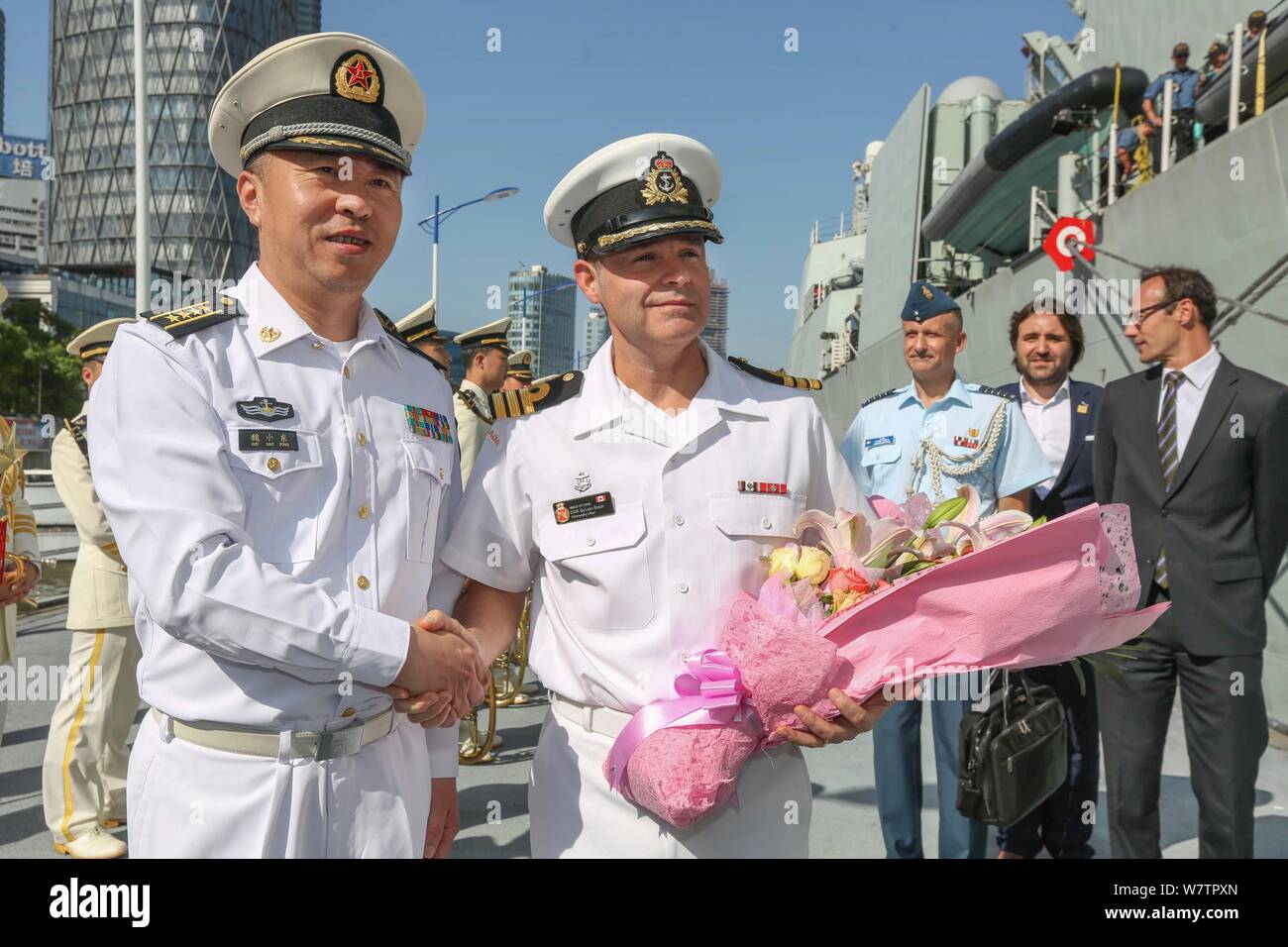 Sylvain Belair, rechts, Kommandant der Kanadischen naval ship HMCS Ottawa, schüttelt Hände mit einem Chinesischen Marine offizielle nach der Ankunft an einer Pier des Jangtse Stockfoto