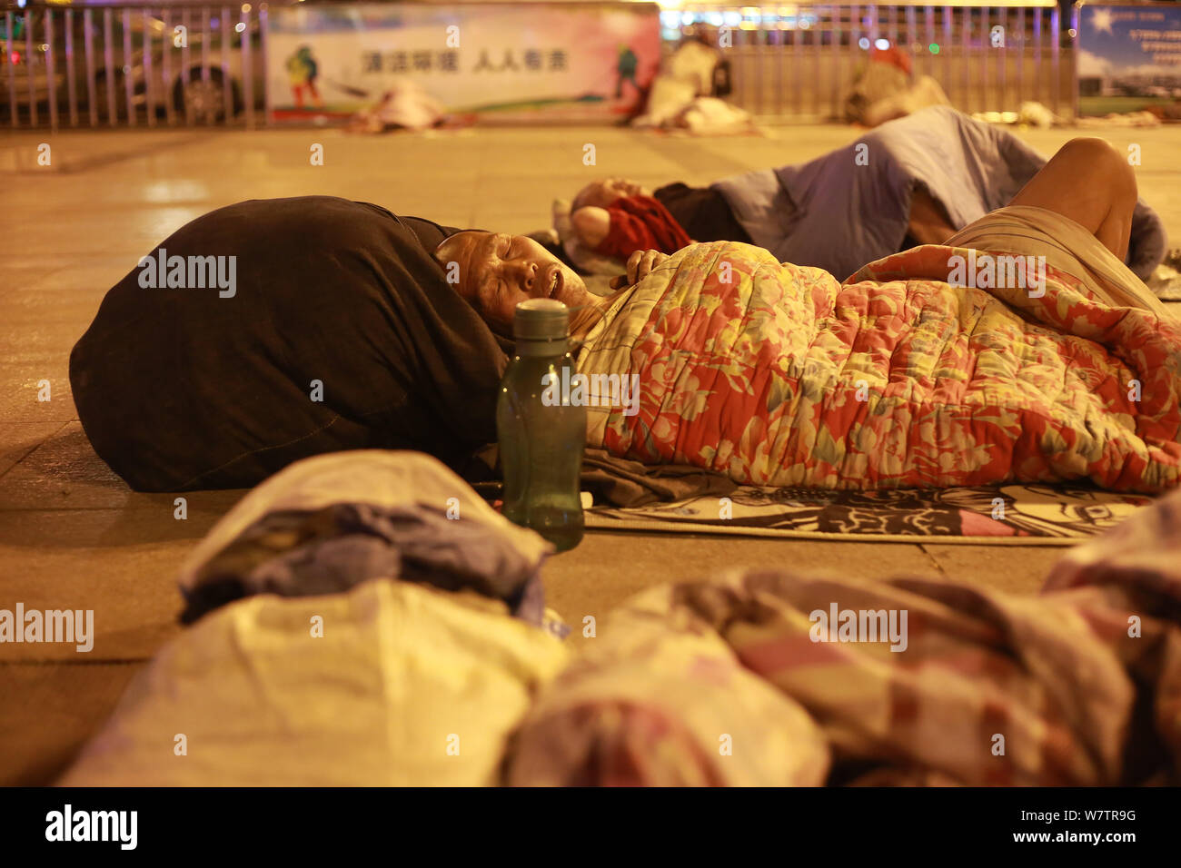Die Passagiere schlafen auf dem Platz von Zhengzhou Bahnhof in Zhengzhou City, Central China Provinz Henan, 18. Mai 2017. Hunderte von passenge Stockfoto