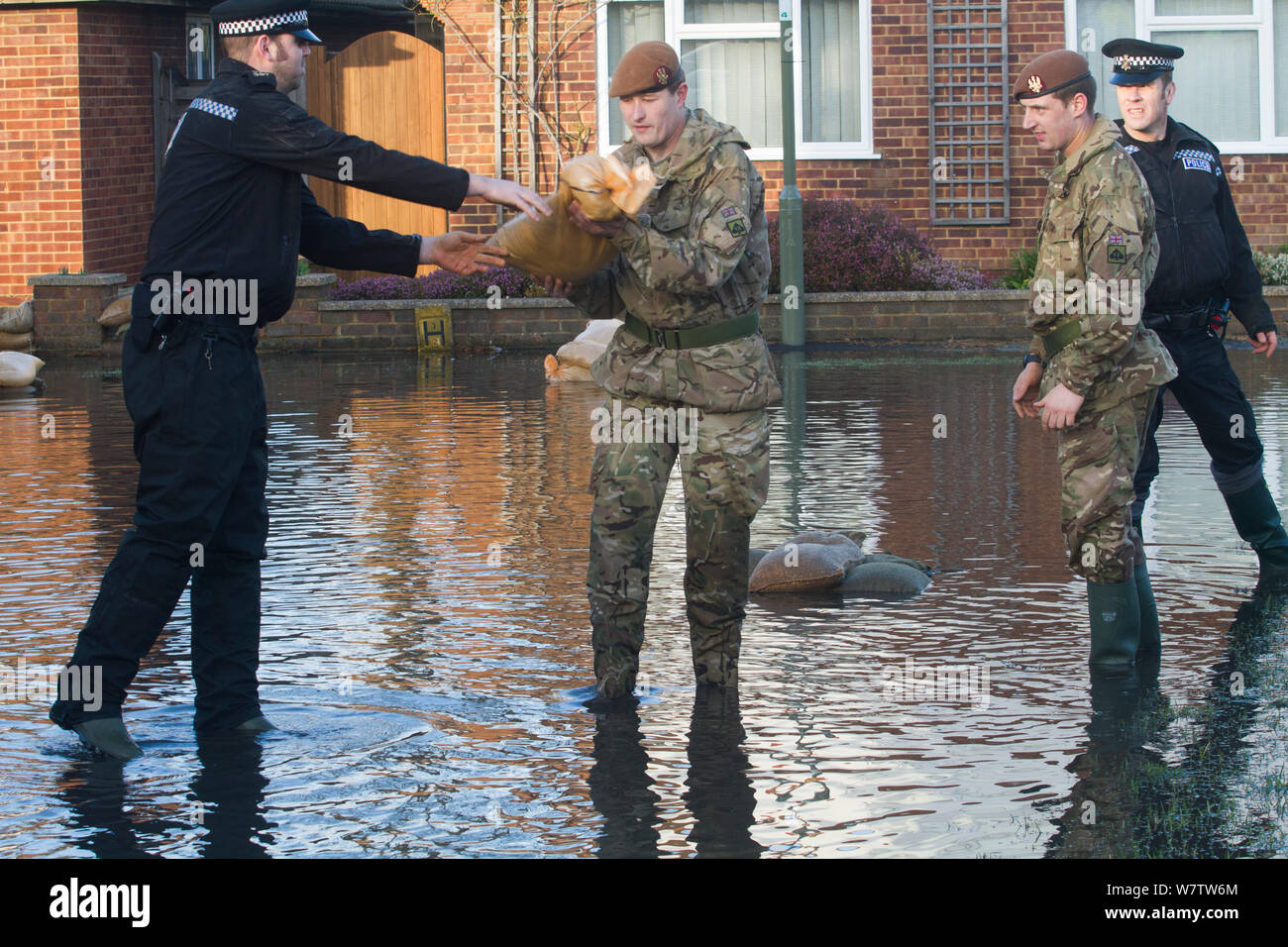 Armee und Polizei in überfluteten Straße nach Februar Überschwemmungen 2014, die Unterstützung für die Bewohner und die Bereitstellung von Sandsäcken, Chertsey, Surrey, England, UK, 16. Februar 2014 zur Verfügung zu stellen. Stockfoto