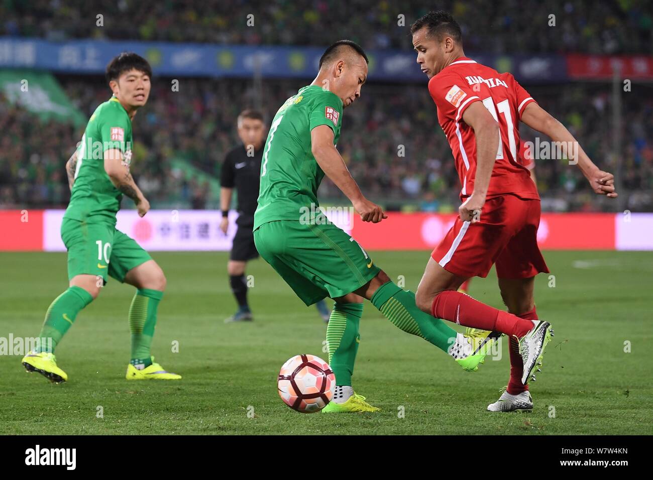 Zhang Läuten von Beijing Guoan, Links, Herausforderungen Brasilianischen Fußballspieler Geuvanio von Tianjin Quanjian in ihre sechste Runde während der 2017 Chi Stockfoto