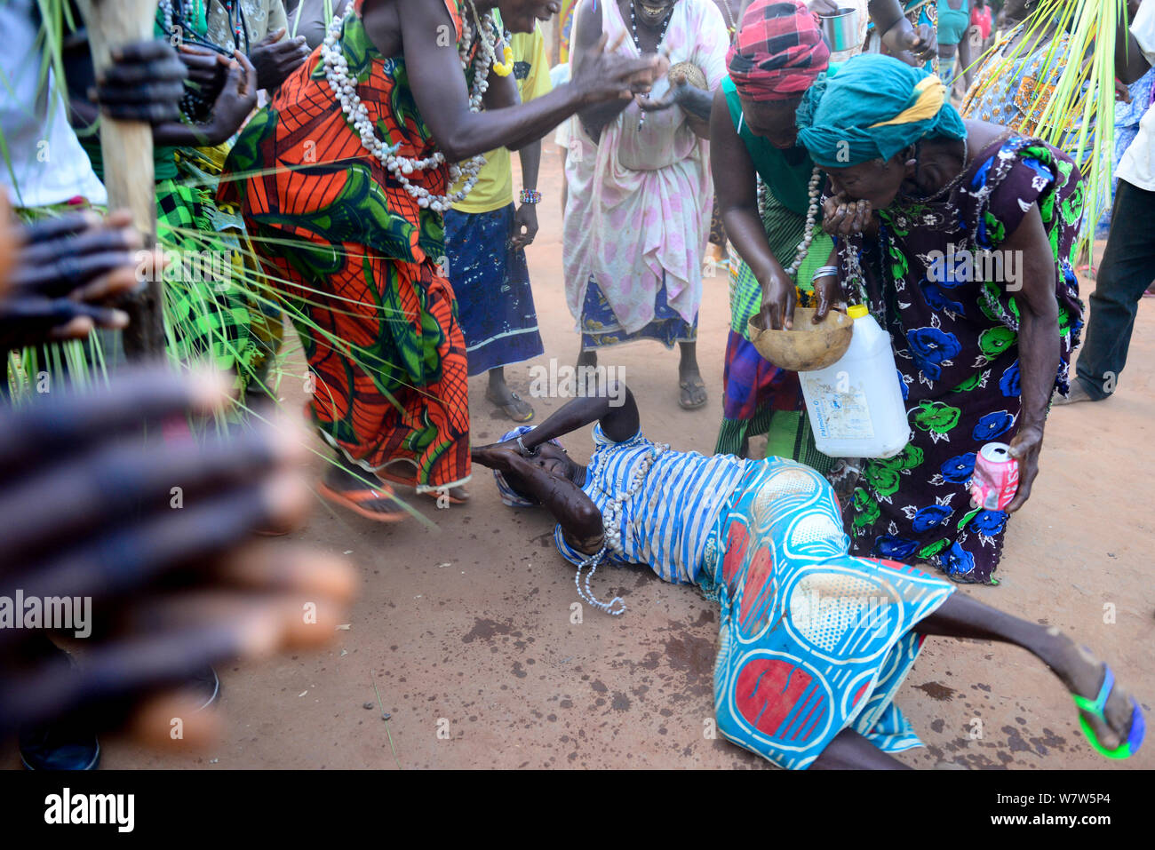 Auf dem Boden liegende Frau mit Wasser während der Nalu rituellen Zeremonie sprengte, Cabedu Dorf, Guinea-Bissau, Dezember 2013. Stockfoto