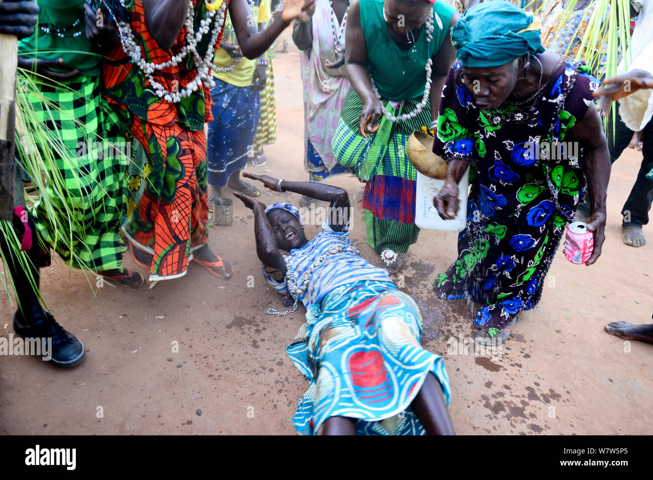 Auf dem Boden liegende Frau mit Wasser während der Nalu rituellen Zeremonie sprengte, Cabedu Dorf, Guinea-Bissau, Dezember 2013. Stockfoto
