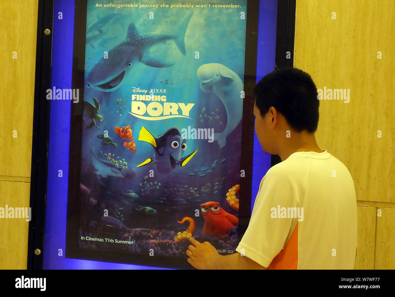 ---- Eine Chinesische filmgoer Spaziergänge Vergangenheit ein Poster der Amerikanischen 3D-computeranimierten Film "Dory" in einem Kino in Kunshan City, Central China H Stockfoto
