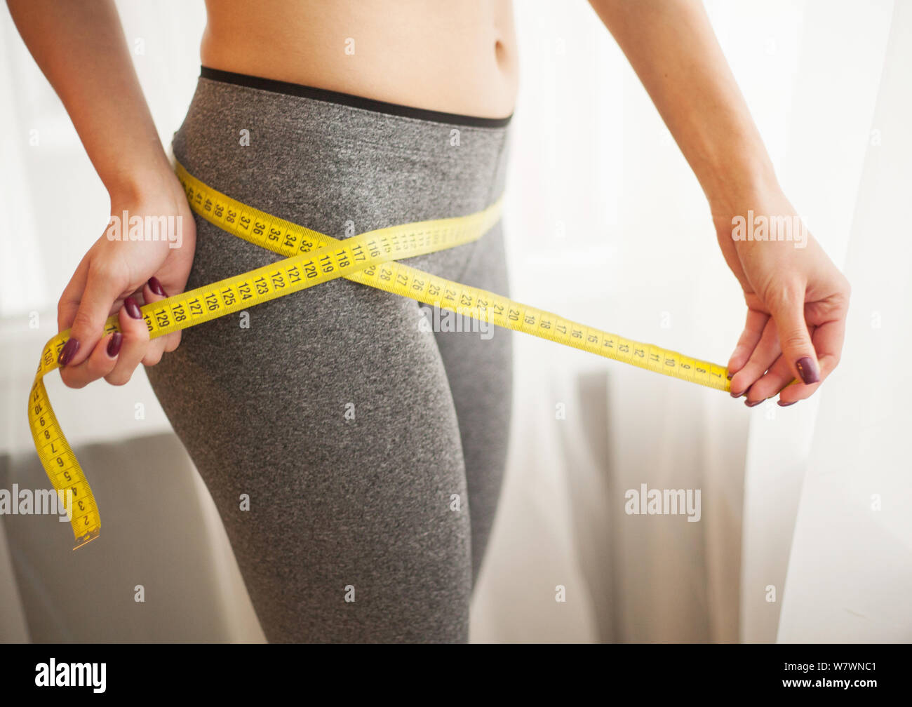 Schlanke junge Frau dünne Taille Messen mit dem Maßband Stockfotografie -  Alamy