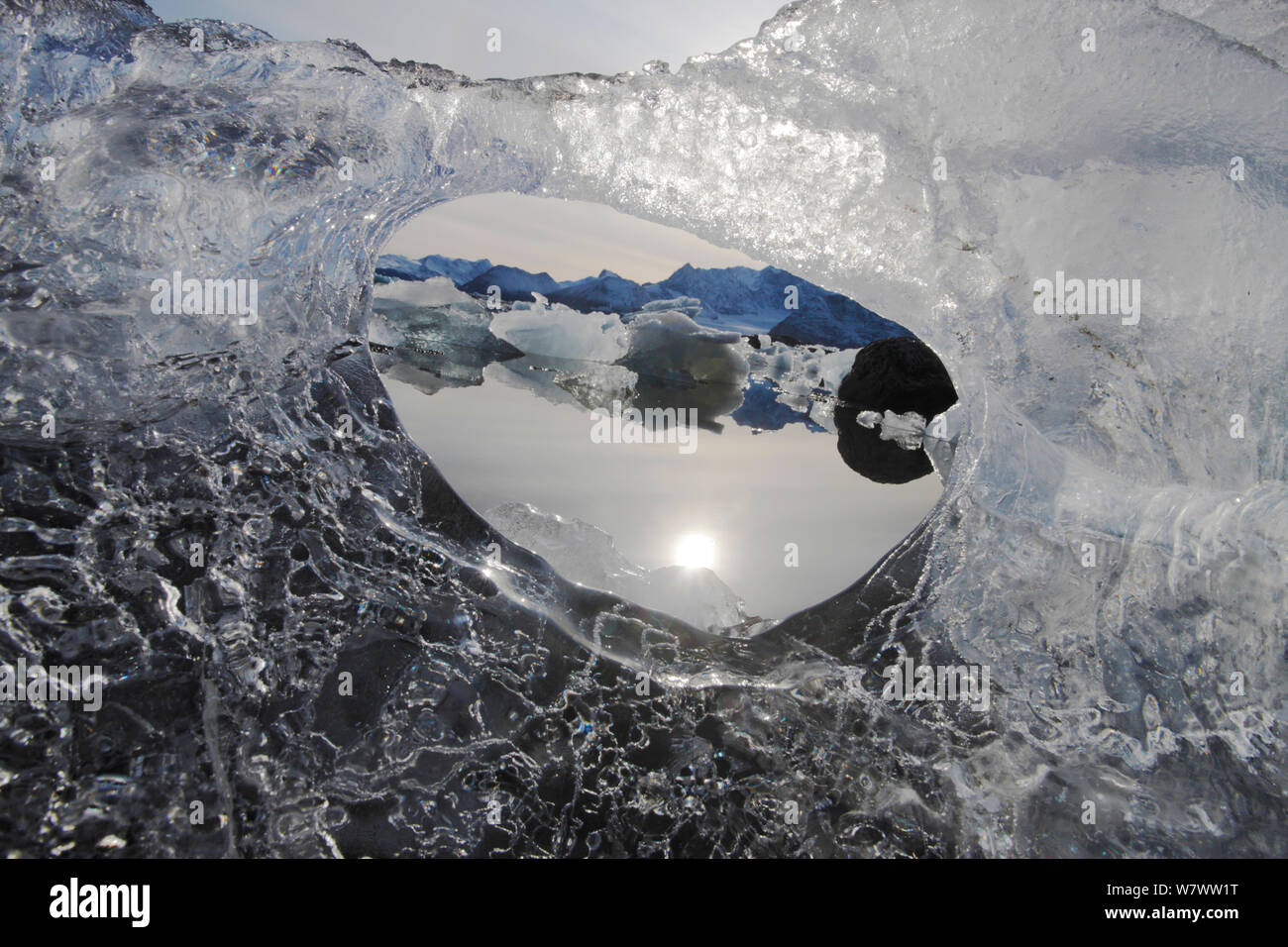 Blick auf die winterliche Landschaft durch das Loch im Eis, Hornsund, Svalbard, Norwegen, September. Stockfoto