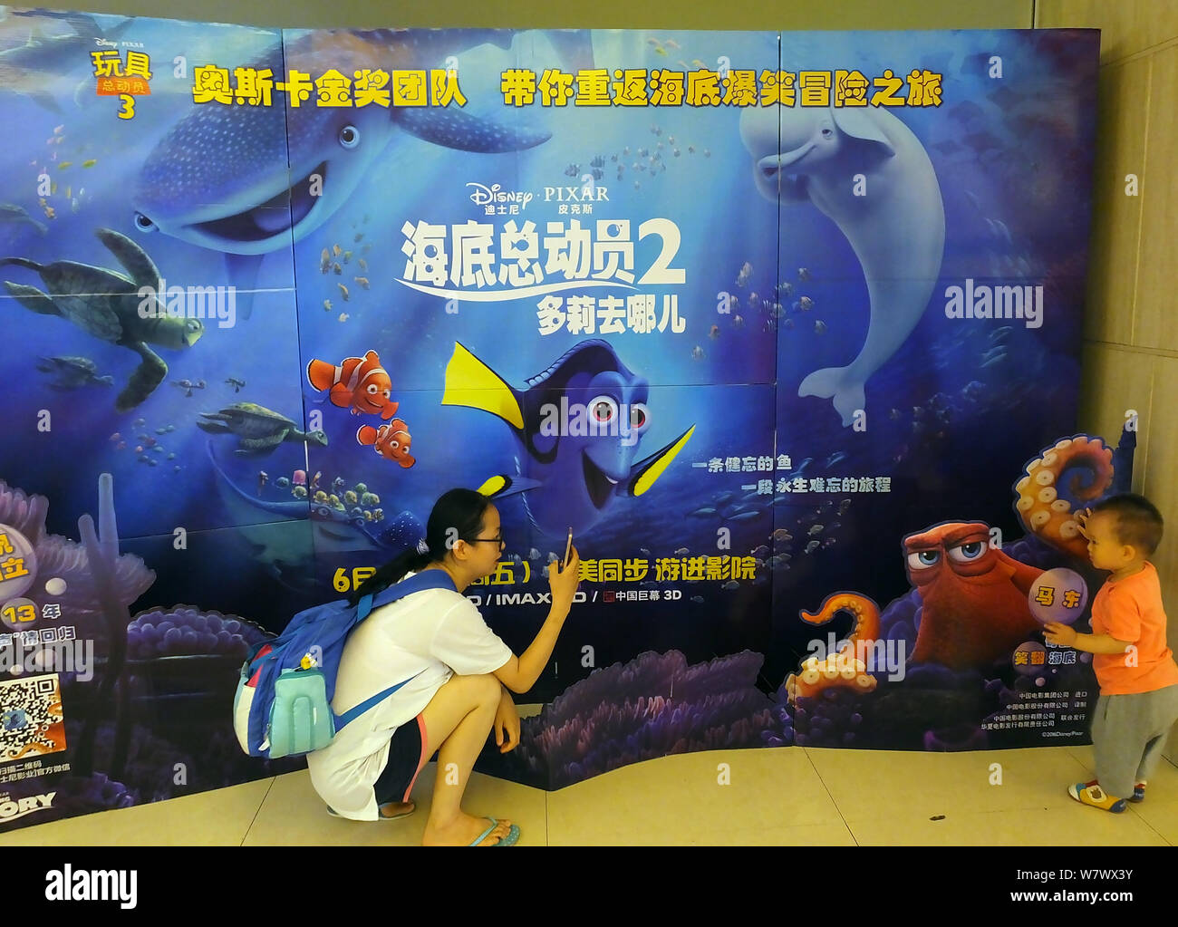 ---- Eine Chinesische filmgoer nimmt Fotos von einem Plakat der Amerikanischen 3D-computeranimierten Film "Dory" in einem Kino in Kunshan City, Central Kinn Stockfoto