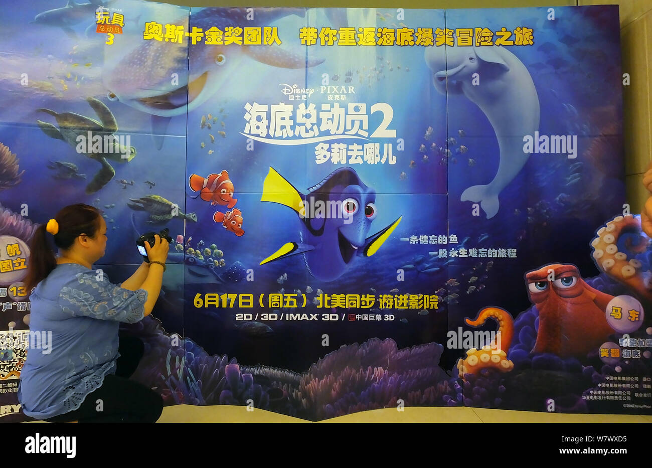 ---- Eine Chinesische filmgoer nimmt Fotos von einem Plakat der Amerikanischen 3D-computeranimierten Film "Dory" in einem Kino in Kunshan City, Central Kinn Stockfoto
