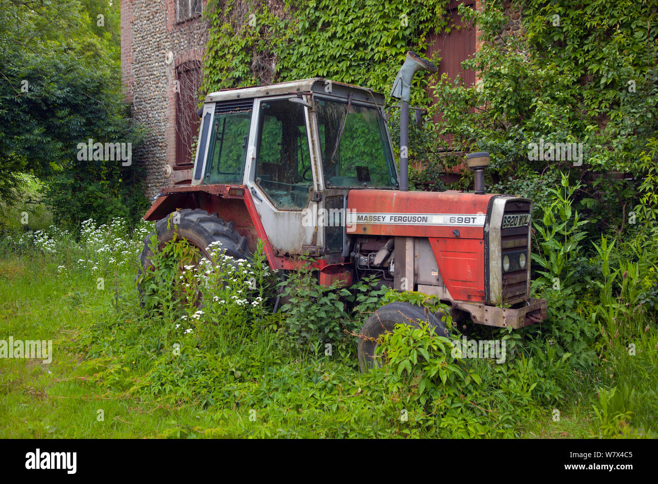 Alte Massey Ferguson 698 T Traktor außerhalb landwirtschaftlicher Gebäude, Norfolk, Großbritannien, Juni 2014. Stockfoto