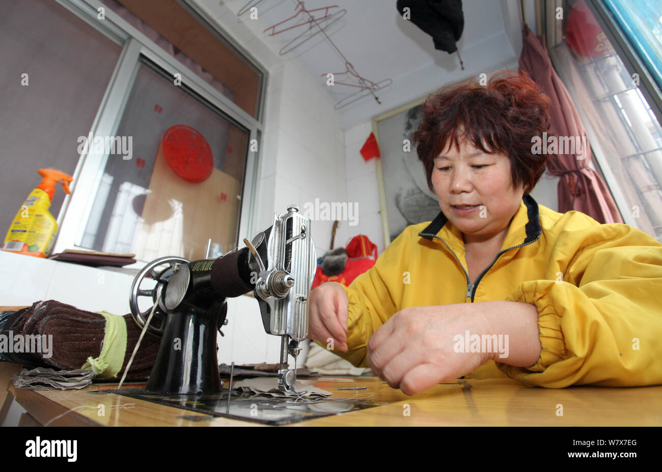 51-jährige Chinesische entlassenen Arbeitnehmer Zhang Qiao' e verwendet eine Nähmaschine eine Einlage zu den Bedürftigen in Sanmenxia Stadt gespendet werden, zentrale Stockfoto