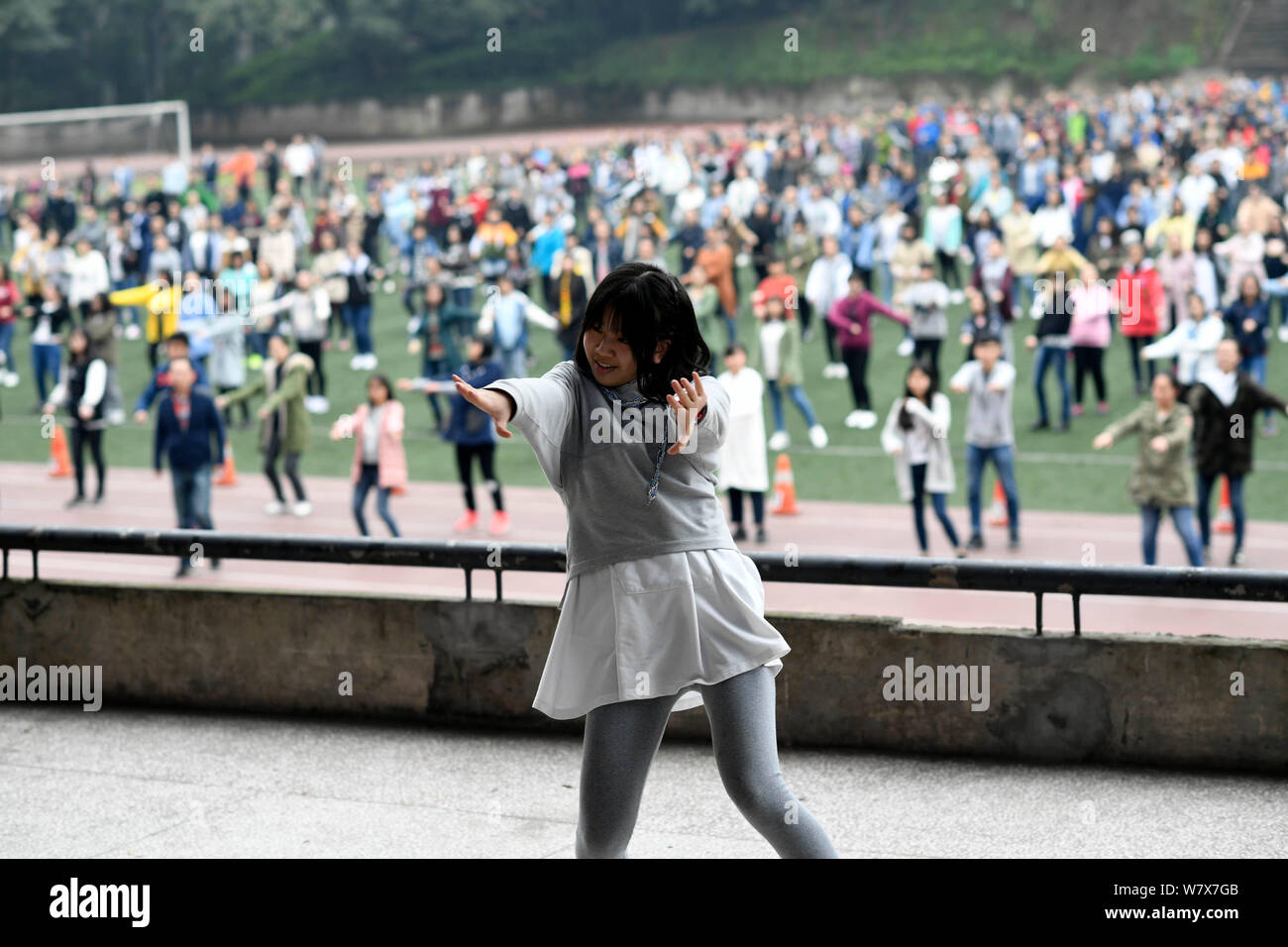 Ein studentischer Vertreter zeigt Street Dance Acts zu anderen Studenten während einer Pause auf dem Spielplatz an der Chongqing Nankai der mittleren Schule in Chong Stockfoto