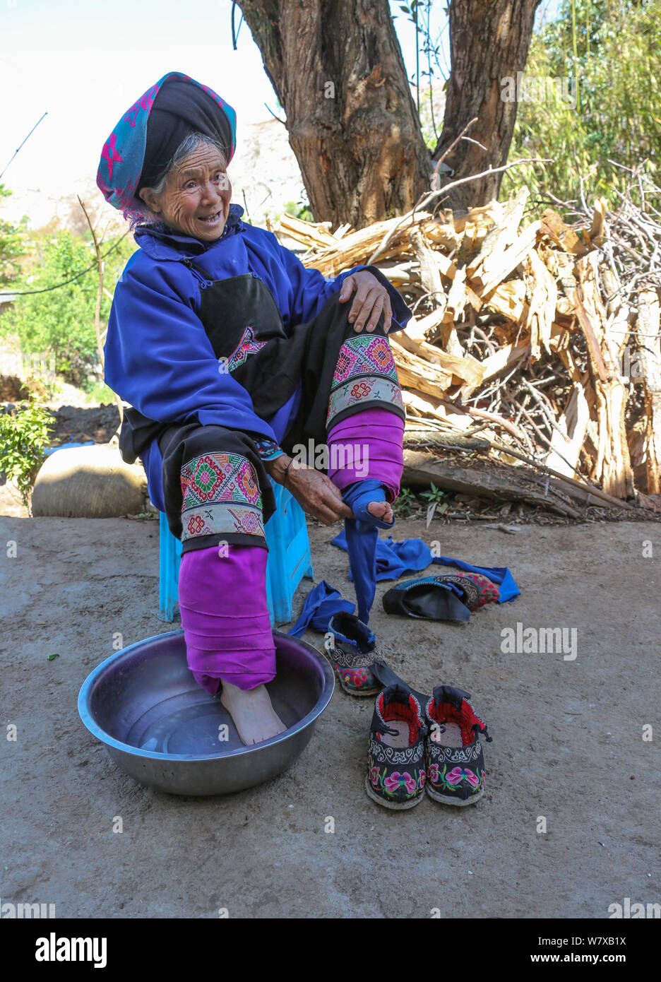 Eine ältere chinesische Frau wäscht ihr gebunden Füße in Weining Yi, Hui, und Miao autonomen Grafschaft, bijie Stadt, im Südwesten Chinas Provinz Guizhou, 19 Apri Stockfoto