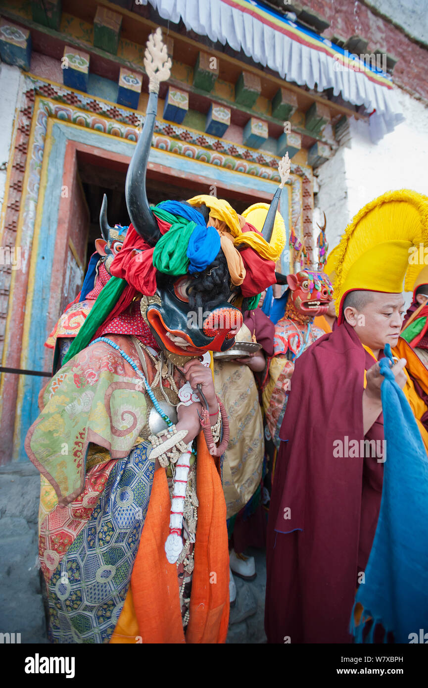 Mönche und Tänzer gehen in einer Prozession aus dem Kloster mit dem &#39; Kuchen &#39; (enthält alle Bösen) am Ende des ersten Tages der Torgya Festival verbrannt werden. Galdan Namge Lhatse Kloster Tawang, Arunachal Pradesh, Indien. Januar 2014. Stockfoto