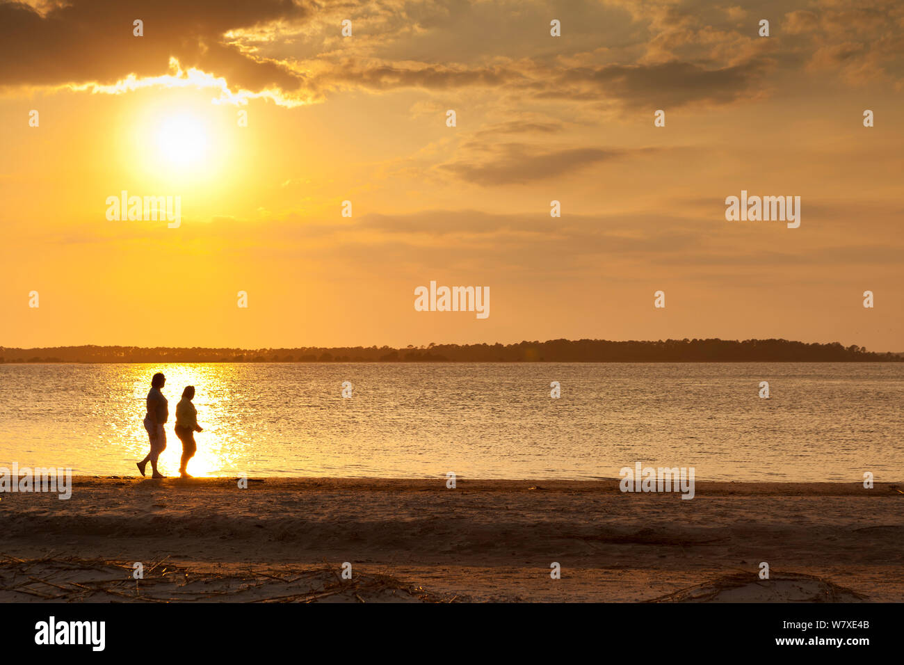 Zwei Menschen zu Fuß entlang der Strand bei Sonnenuntergang am südlichen Ende der Edisto Island, South Carolina, USA. Stockfoto