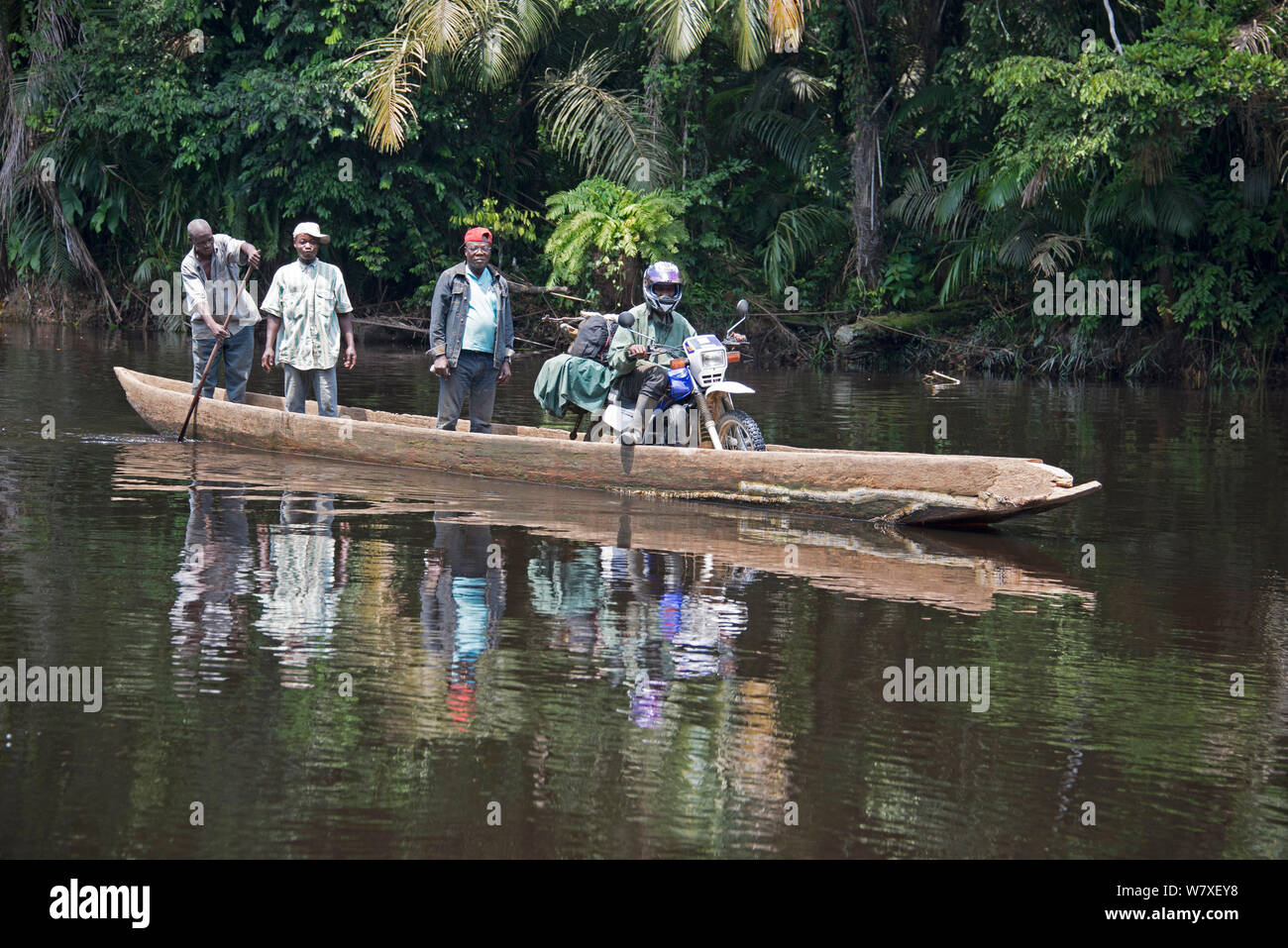 Die lokale Bevölkerung Fluß in Holz- Einbaum, einschließlich Menschen mit Gütern auf Motorrad, Salonga National Park, Equateur, Demokratische Republik Kongo, Mai 2012. Stockfoto