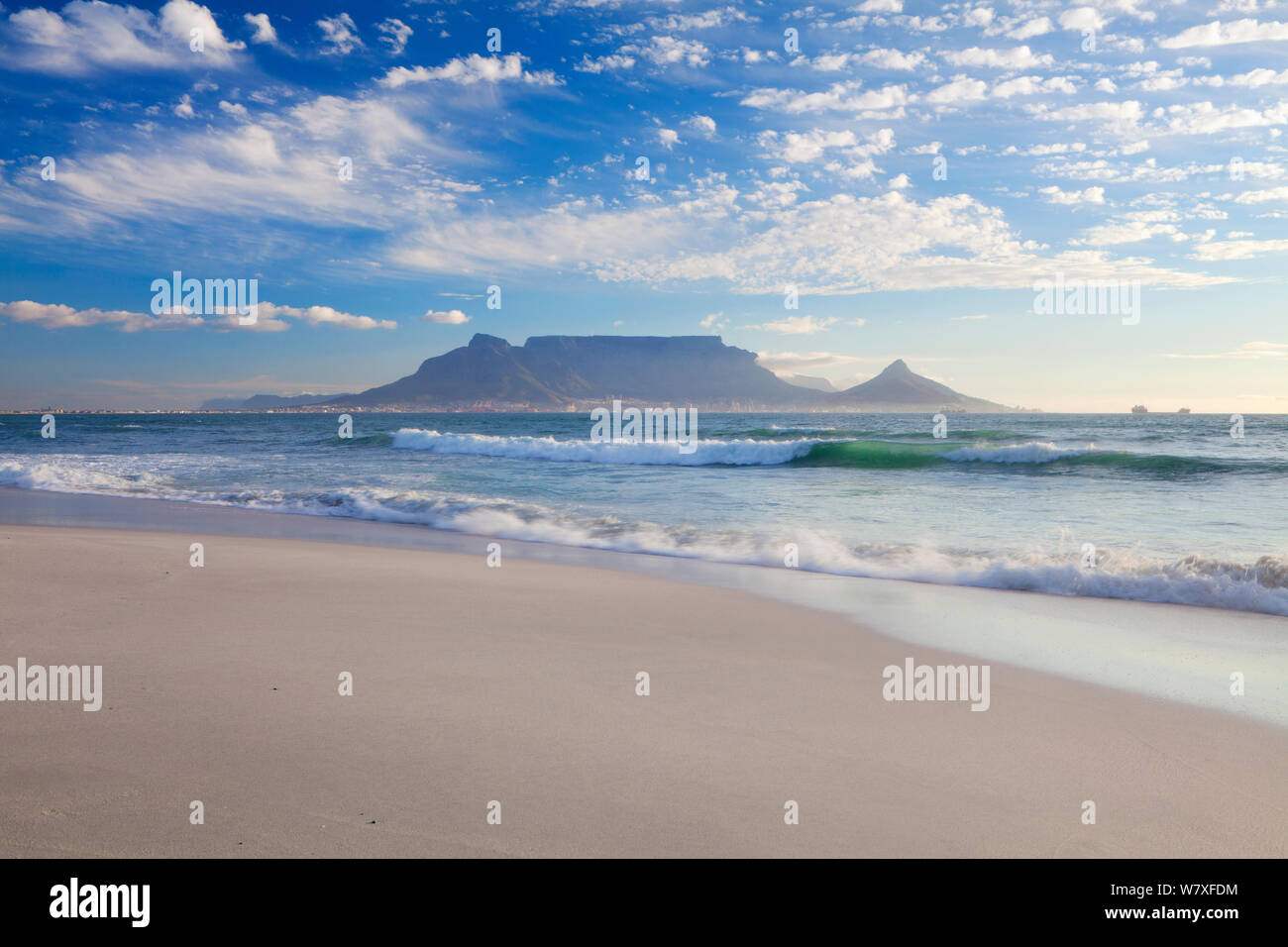 Wave waschen über Strand in der Dämmerung mit dem Tafelberg im Hintergrund. Bloubergstrand, Kapstadt, Südafrika. Oktober 2011. Nicht-ex. Stockfoto