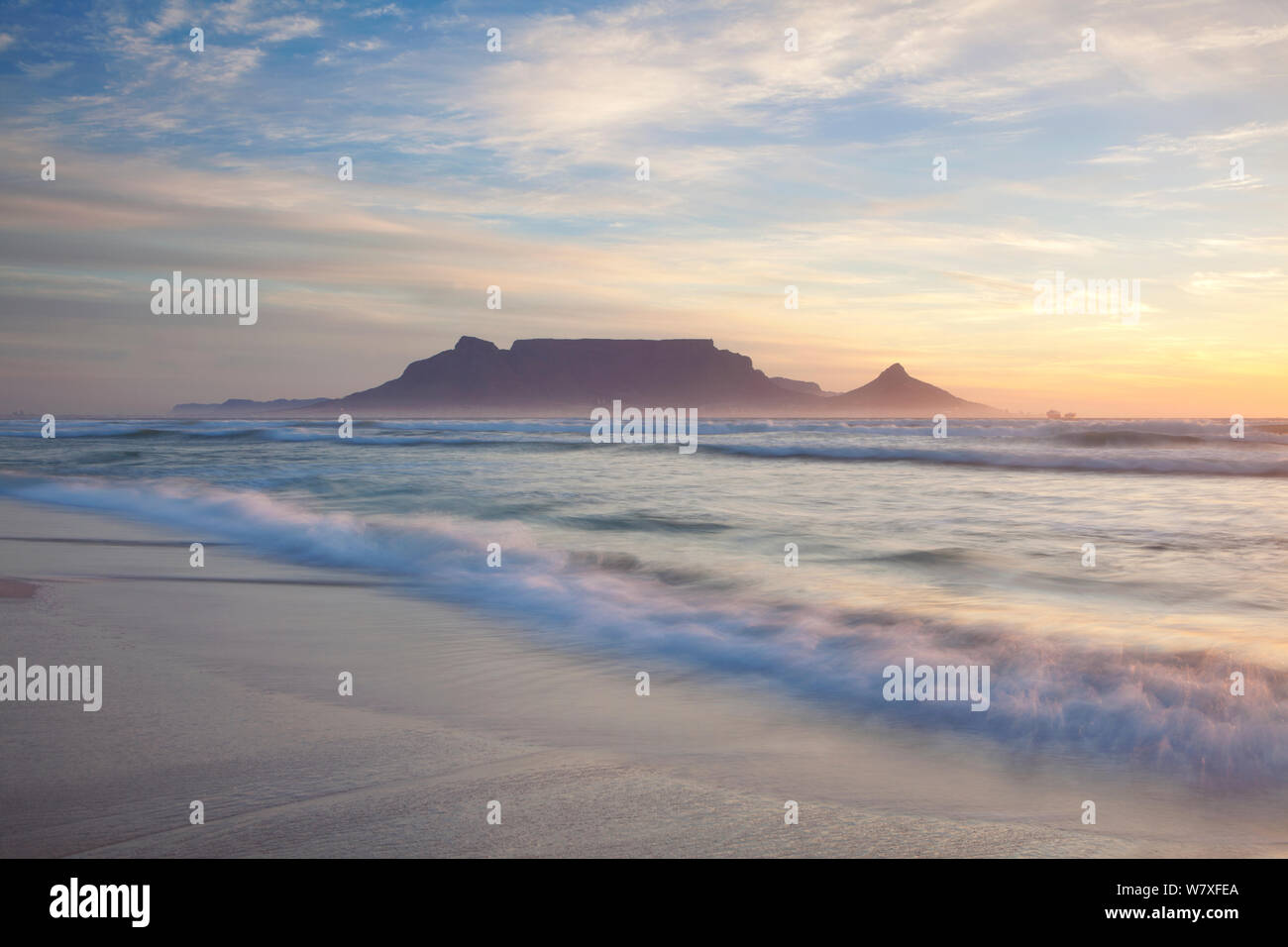 Wave waschen über Strand bei Sonnenuntergang mit dem Tafelberg im Hintergrund. Bloubergstrand, Kapstadt, Südafrika. November 2011. Nicht-ex. Stockfoto