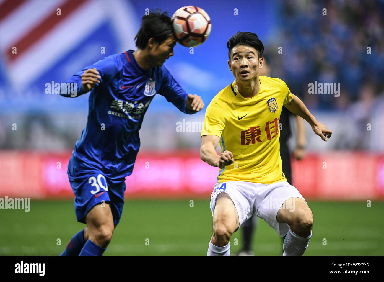 Tao Jin Grönland von Shanghai Shenhua F.C., Links, Herausforderungen Ji Xiang der Jiangsu Suning F.C. während der ersten Runde der 2017 chinesischen Super Stockfoto
