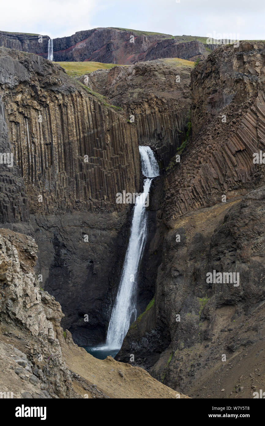 Litlanesfoss fallen durch spektakuläre Basaltsäulen, Strom der Hengifoss, die in der Ferne sehen kann. Hengifoss, East Island, Island. August. Stockfoto