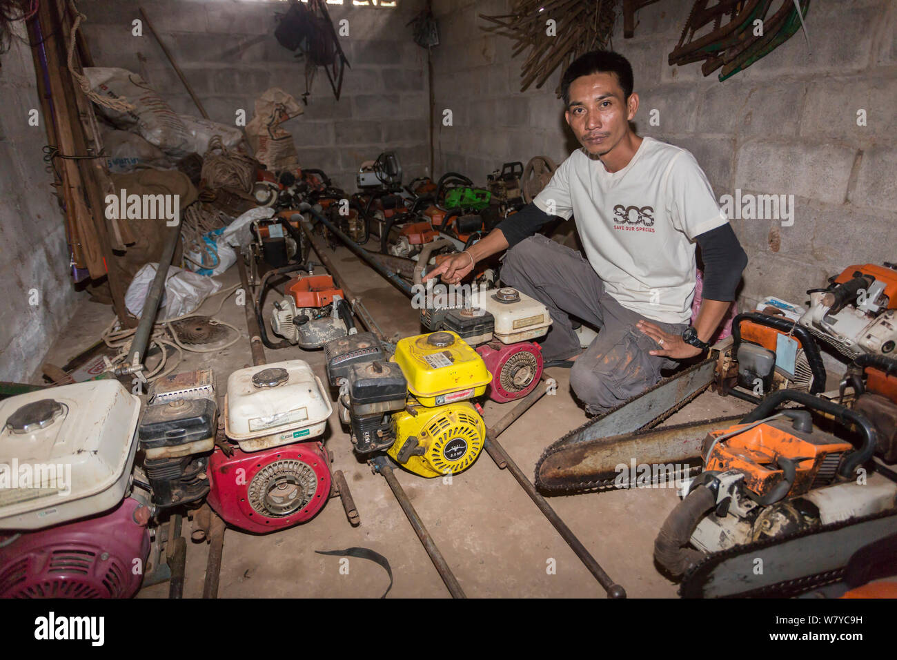 Sayan Raksachart von Freeland Foundation, mit dem beschlagnahmten Außenbordmotoren und Kettensägen von Siam Palisander baum Wilderer verwendet, Thap Lan-Nationalpark, Dong Phayayen-Khao Yai Forest Complex, Ost Thailand, August, 2014. Stockfoto