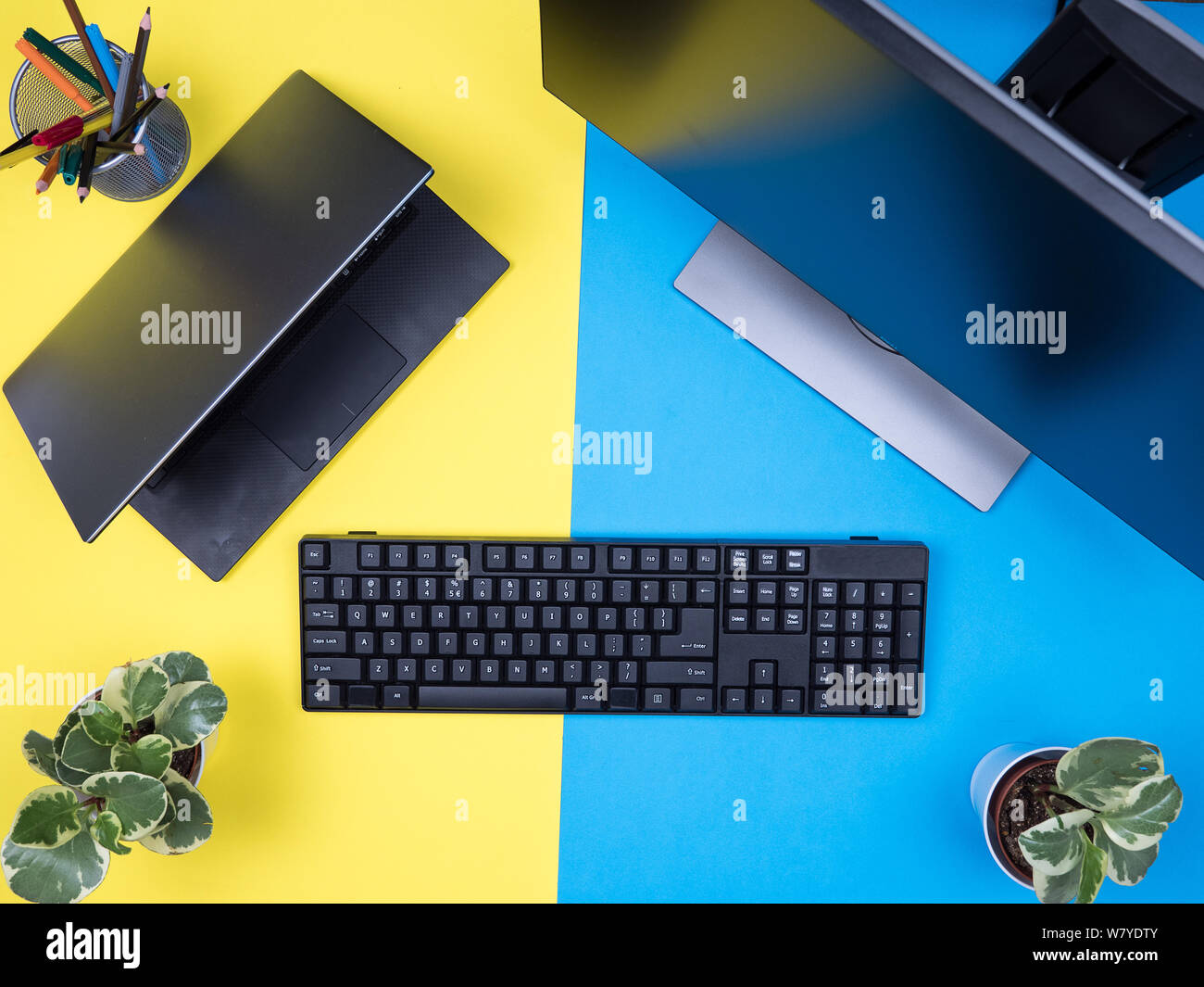 Flach Blick von oben auf die Tastatur neben modernen Laptop über blauen Hintergrund. Workplace Konzept. Stockfoto