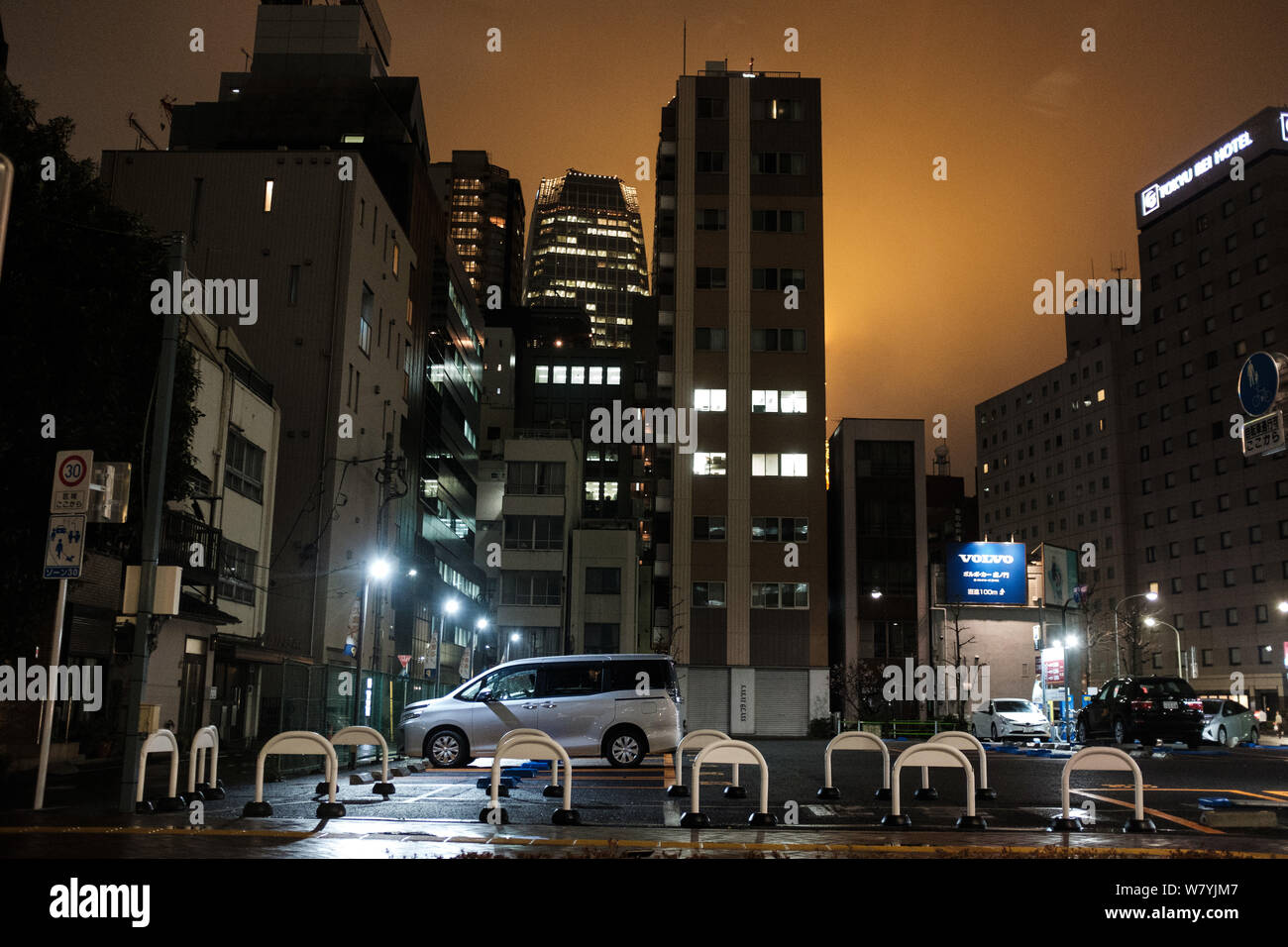 Night Shot der städtischen Parkplatz durch hohe Gebäude in der Innenstadt von Tokio, Japan Stockfoto
