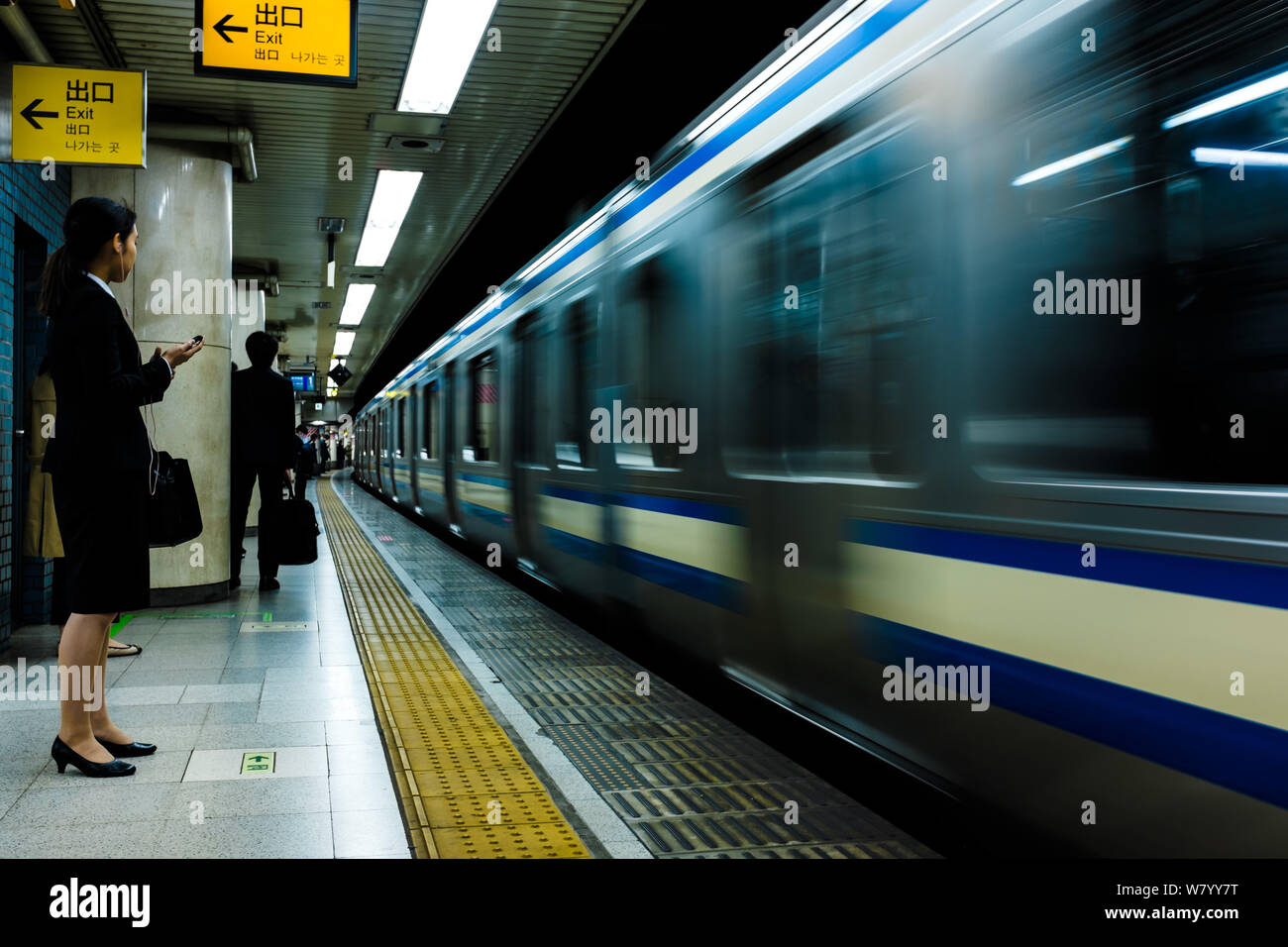 Eine Frau, die in der U-Bahn in Tokio, Japan, auf den Zug wartet Stockfoto