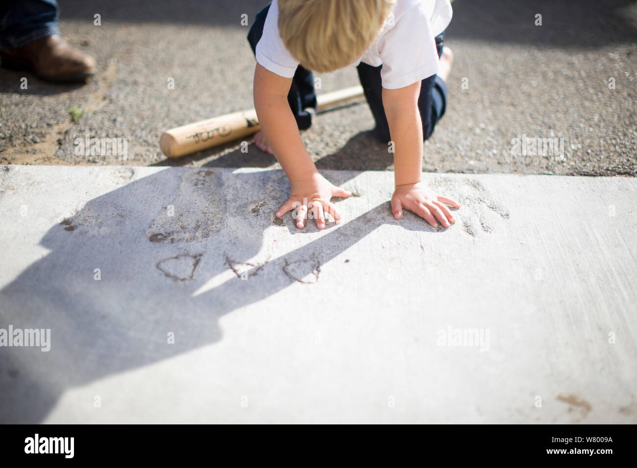 Junge seine Hände drücken in feuchtem Zement im Freien. Stockfoto