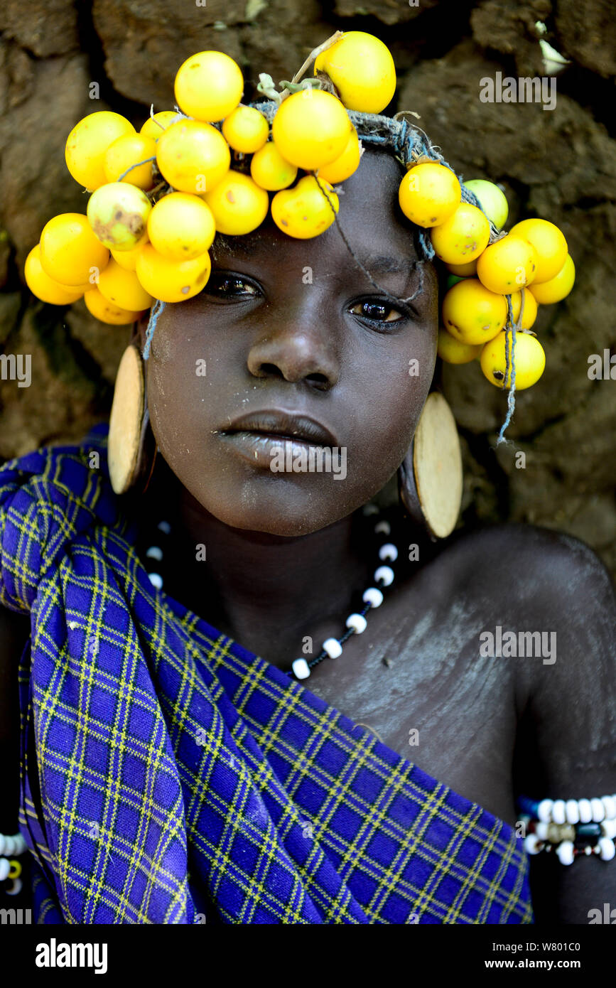 Mursi Mädchen mit ihrem traditionellen Kopfschmuck von Obst, Mursi Stamm. Mago National Park. Äthiopien, November 2014 Stockfoto
