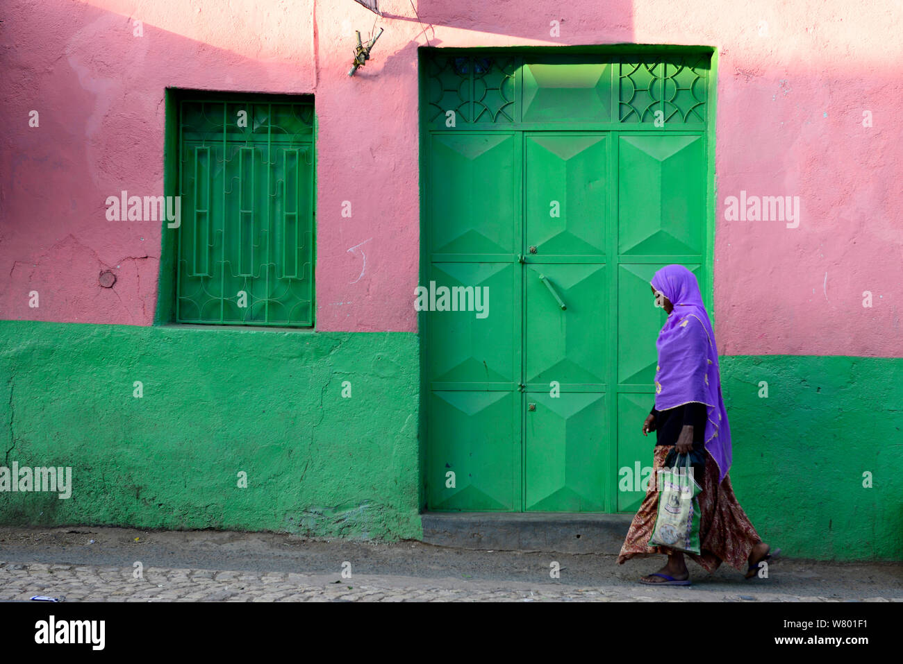 Muslimische Frau hinunter bunte Gassen, in Harar, eine wichtige heilige Stadt in der islamischen Glaubens, UNESCO-Weltkulturerbe. Äthiopien, November 2014 Stockfoto