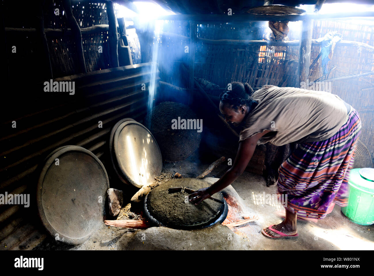 Karo Frau kochen in der traditionellen Küche. Karo Stammes, Omo River. Äthiopien, November 2014 Stockfoto