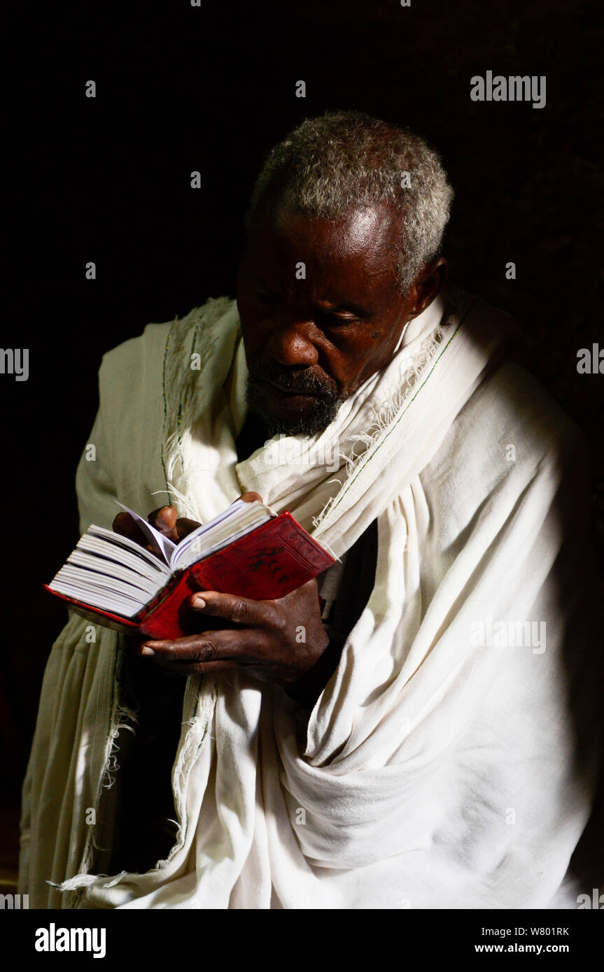 Priester Lesen der Bibel in Wette Maryaml Kirche (Teil der nordwestlichen Gruppe von Kirchen in Lalibela). UNESCO-Weltkulturerbe. Lalibela. Äthiopien, Dezember 2014. Stockfoto