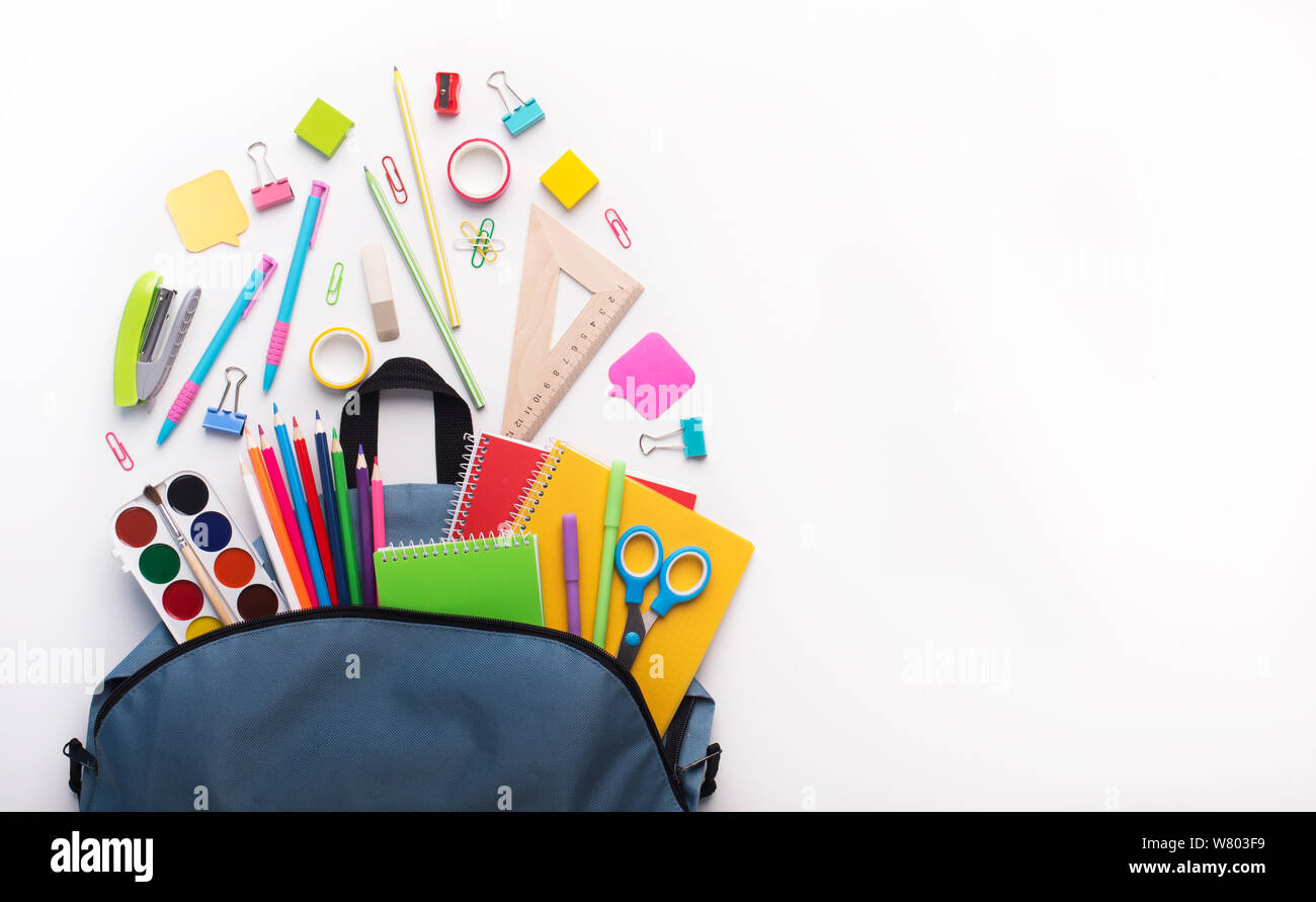 Schule Rucksack mit Schreibwaren innen geöffnet auf Weiß Stockfoto