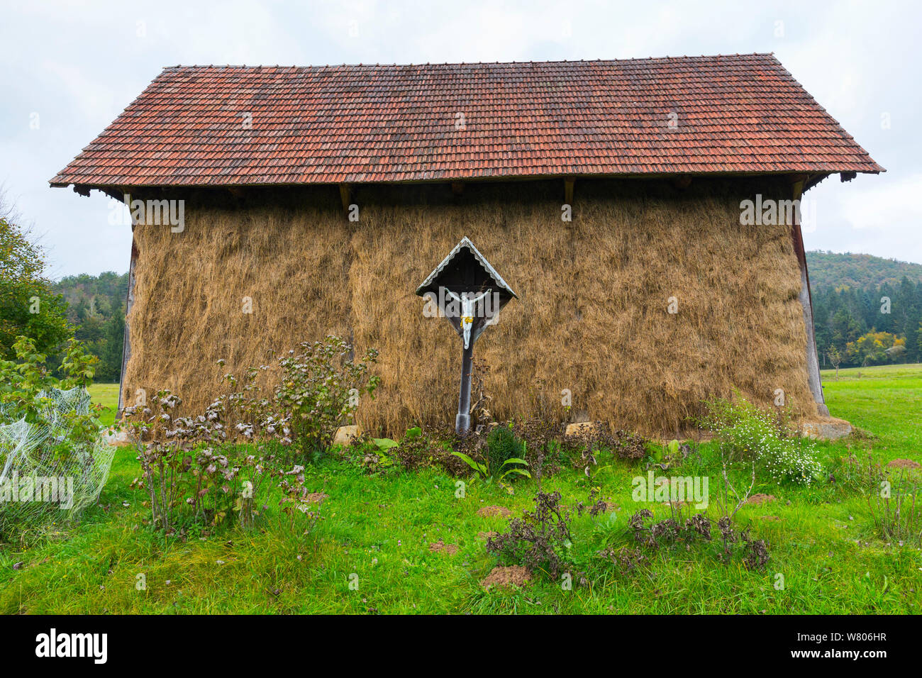 Alte Scheune, mit Kruzifix ausserhalb, in der Nähe der See Cerknika, Grüner Karst, Slowenien, Oktober 2014 Stockfoto