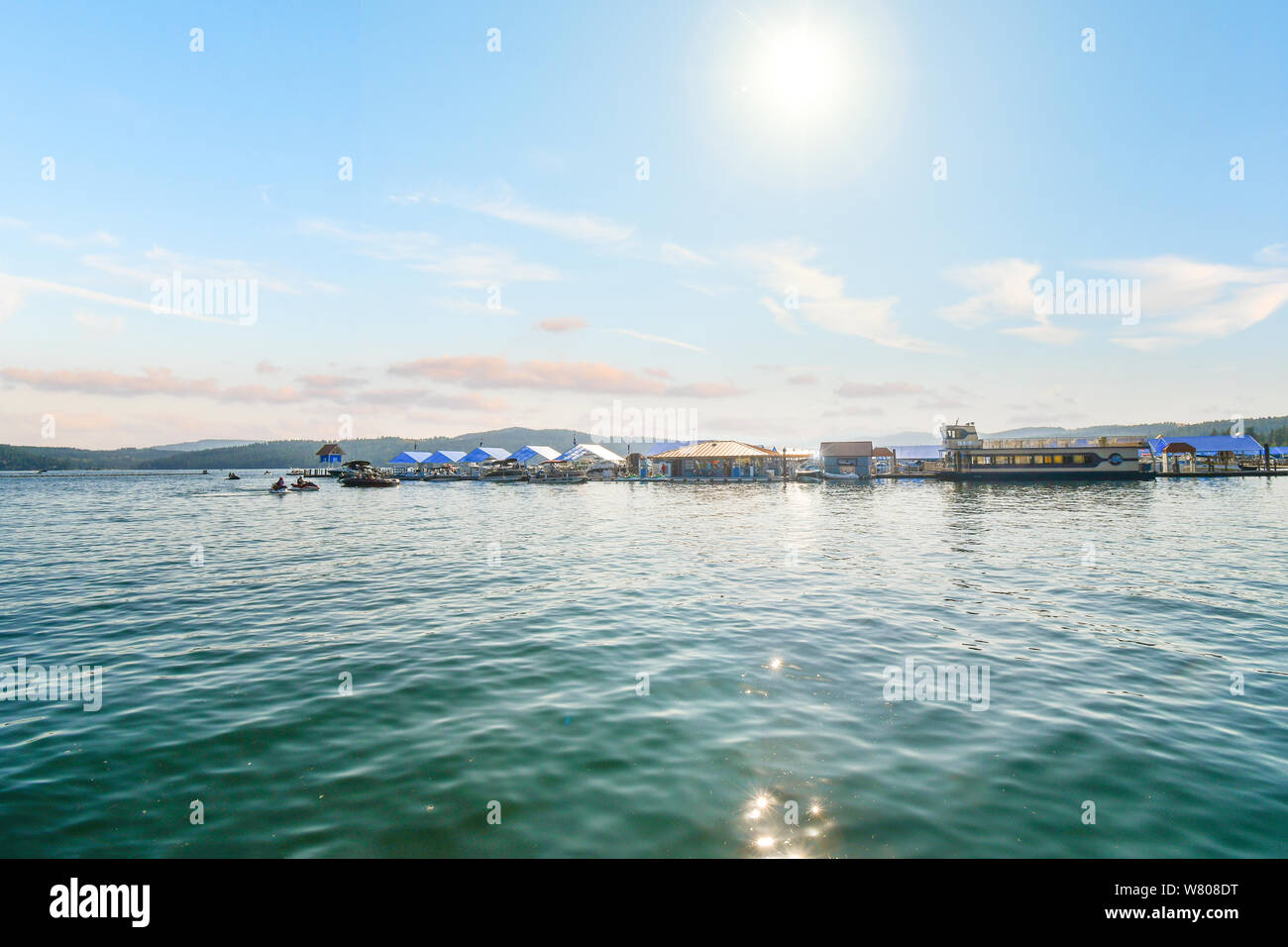 Die heiße Sonne beginnt vor über einem See Marina und Dock auf Lake Coeur d'Alene, Idaho, Touristen und Einheimische Wassersport, Boote und Jetskis genießen Stockfoto