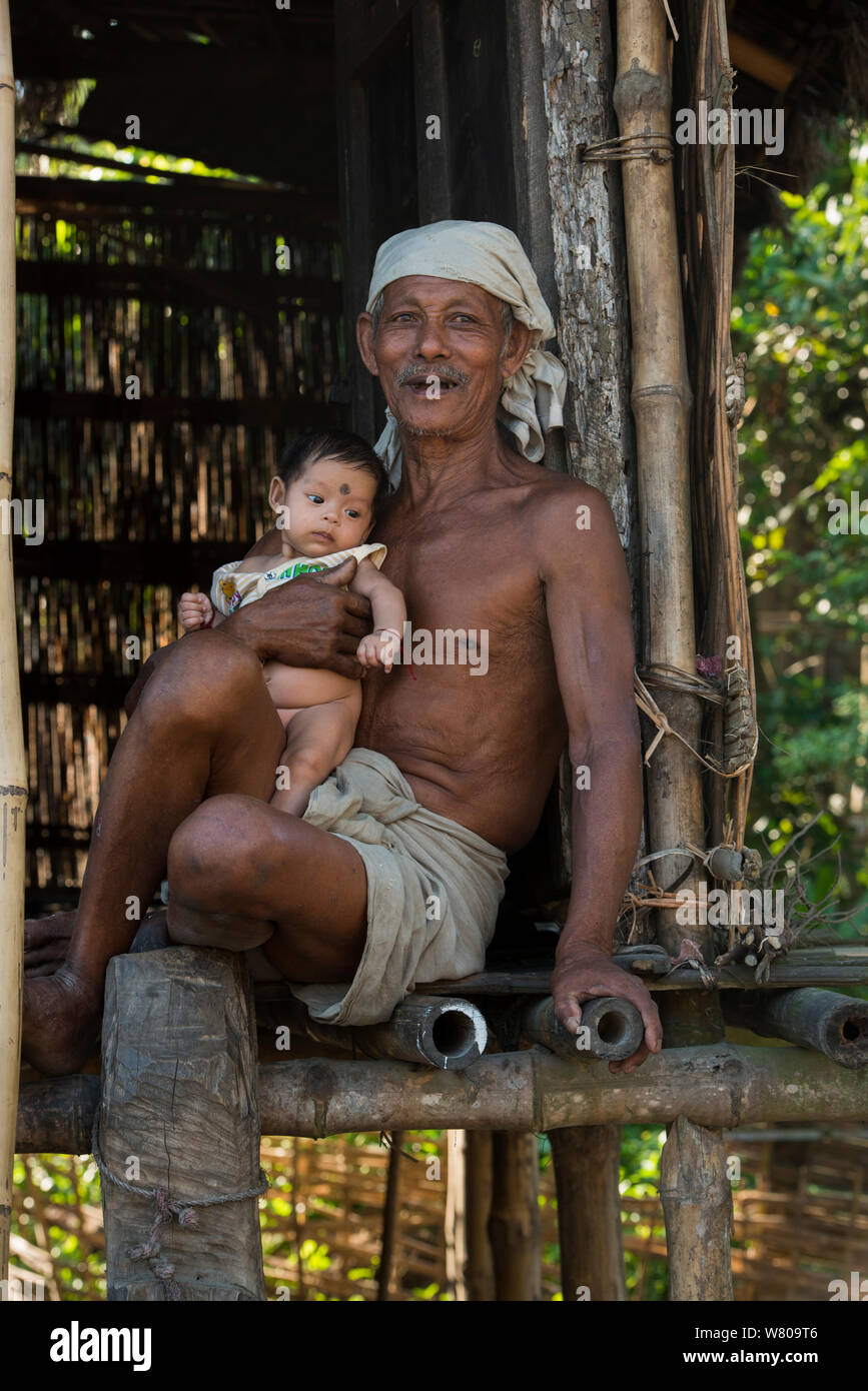 Programmanfang Mann mit Baby, Majuli Island, Brahmaptura Fluss, Assam, North East India, Oktober 2014. Stockfoto