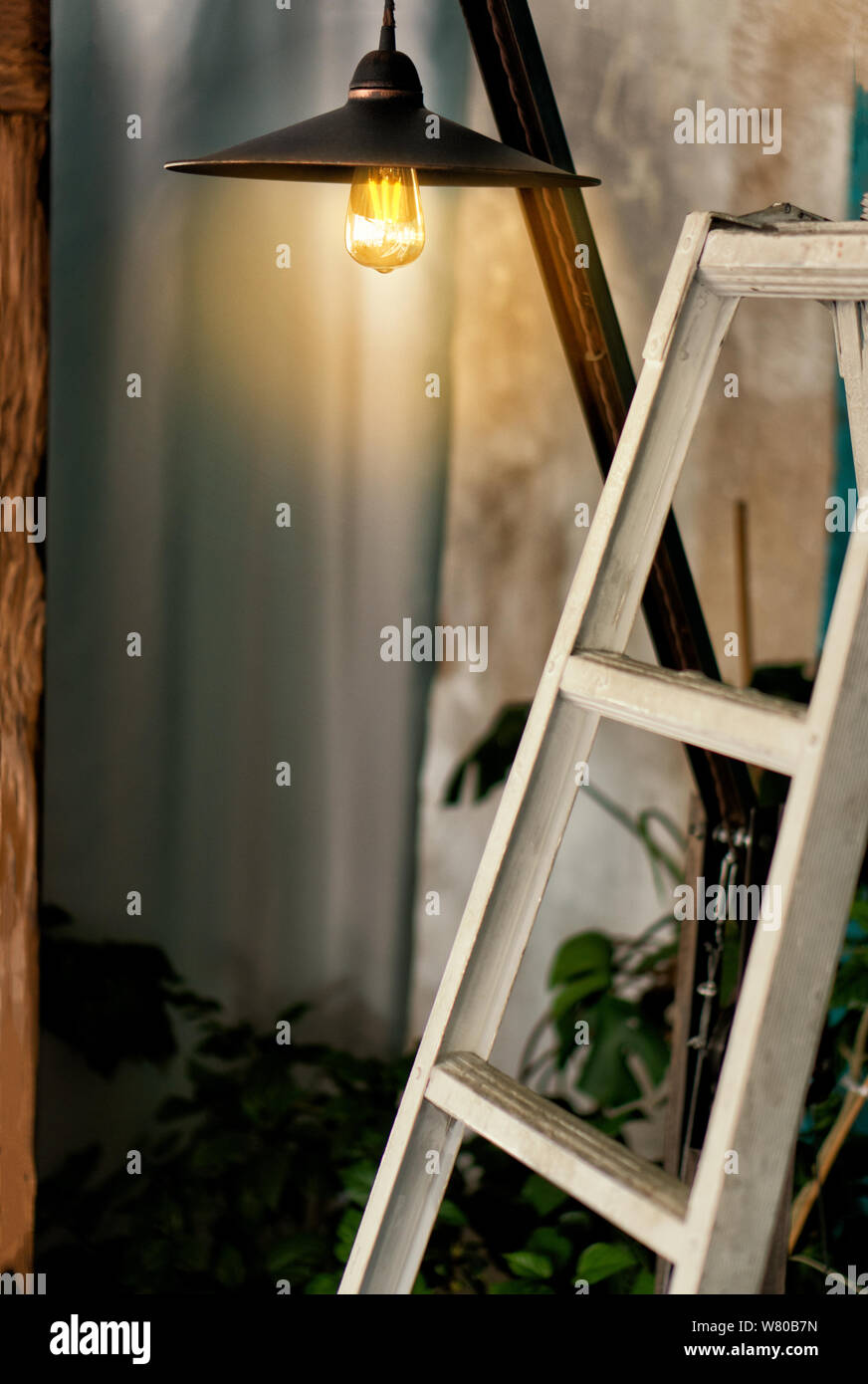 Der Innenraum ist ein Loft Stil, die edisson Lampe glänzt mit einem warmen Stil, der weißen Treppe ist eine Einrichtung. Ruhe lifestyle Zone ohne Eile. Stockfoto