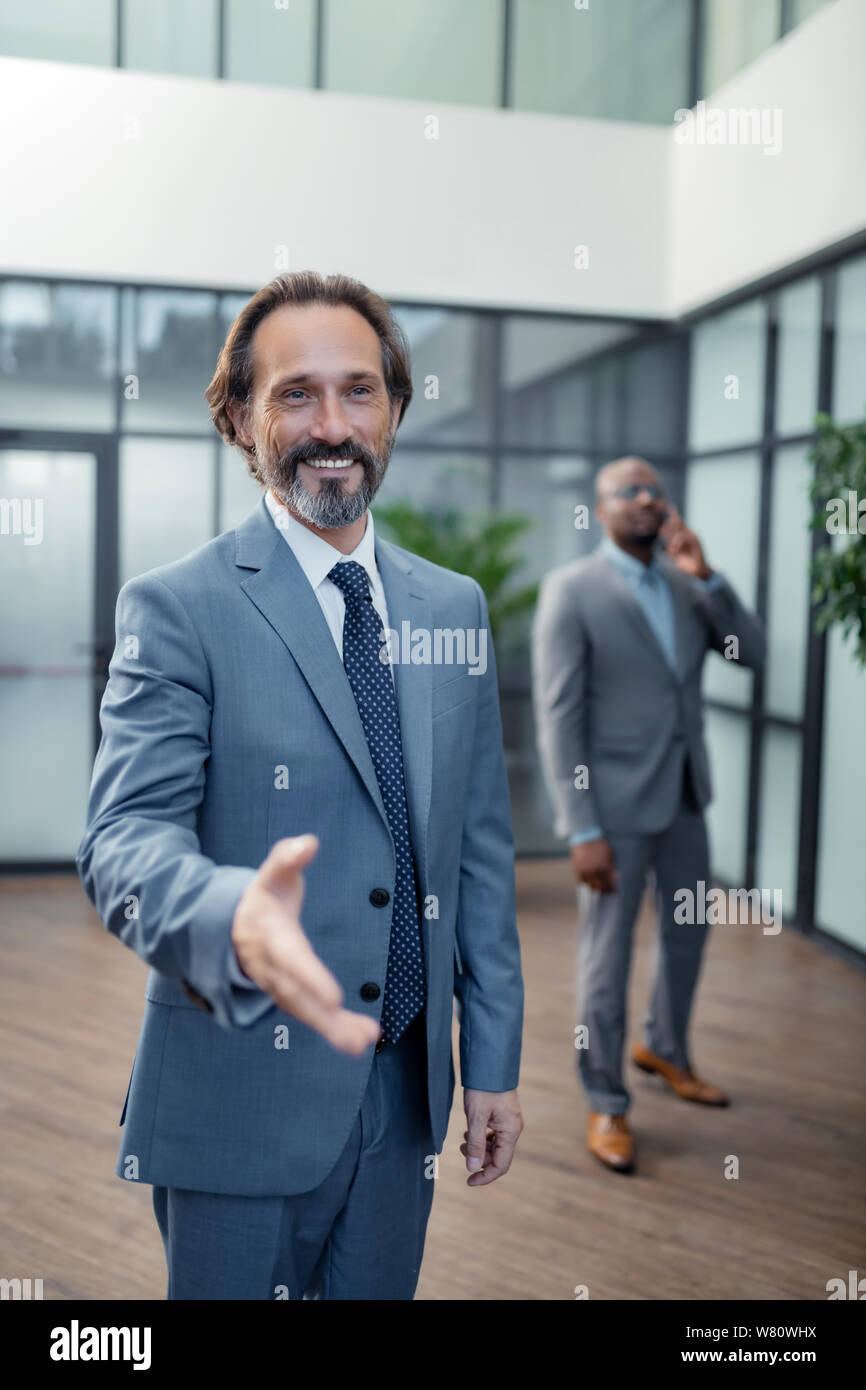 Geschäftsmann seine Hand aus, um Kollegen, während Begrüßung Stockfoto