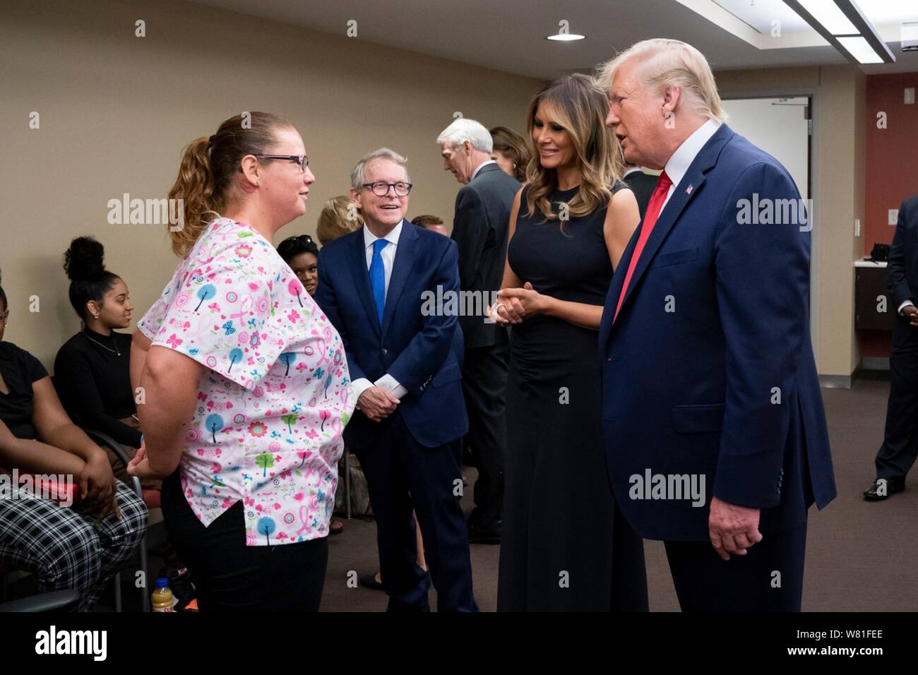 Dayton, Vereinigten Staaten von Amerika. 07 Aug, 2019. Us-Präsident Donald Trump, erste Dame Melania Trump und Ohio reg. Mike DeWine, Mitte, Besuch mit Krankenhauspersonal und Familienangehörigen in Miami Valley Hospital am 7. August 2019 in Dayton, Ohio. Neun Menschen wurden bei einem Shooting im Oregon District von Dayton, Ohio am Tag nach dem 31 Menschen wurden bei Massenerschießungen in El Paso getötet getötet. Credit: Planetpix/Alamy leben Nachrichten Stockfoto