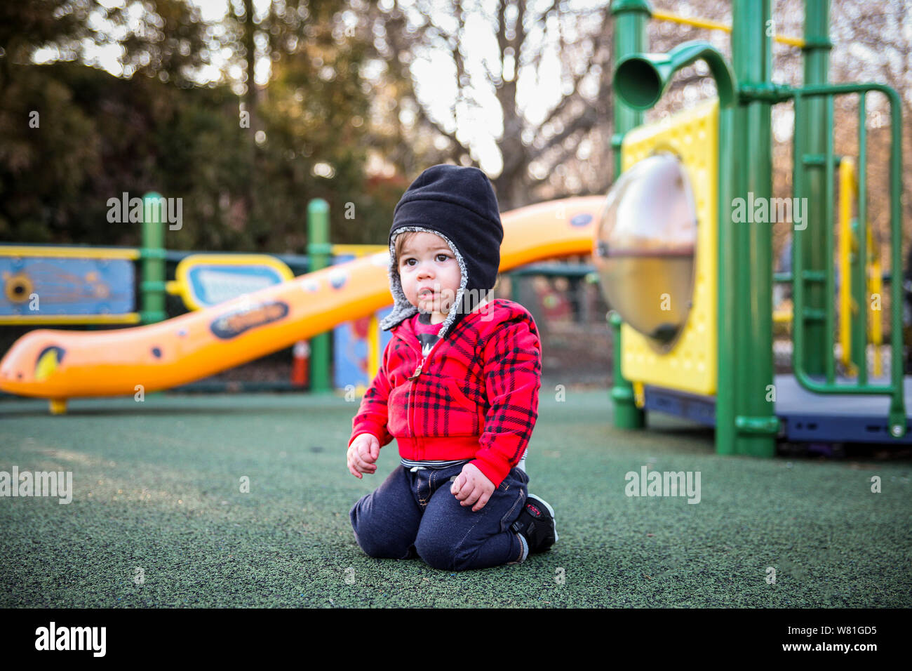 Junge Junge kniend am Spielplatz Stockfoto