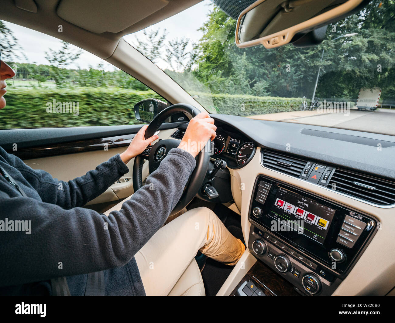 Bloemendaal, Niederlande - 16.August 2018: Innenansicht des modernen Auto mit selbstbewussten jungen Frau, die auf der kleinen Straße von Bloemendaal Stockfoto