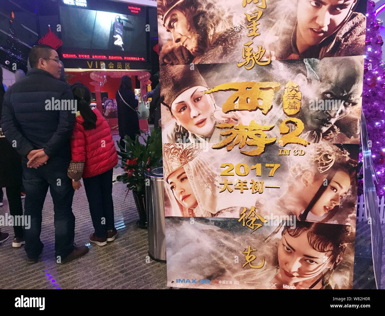 ------ Chinesische Zuschauer neben einem Plakat des Films "Die Reise nach Westen: Die Dämonen Schlagen zurück" in einem Kino in Shanghai, China, 29. Januar stehen Stockfoto