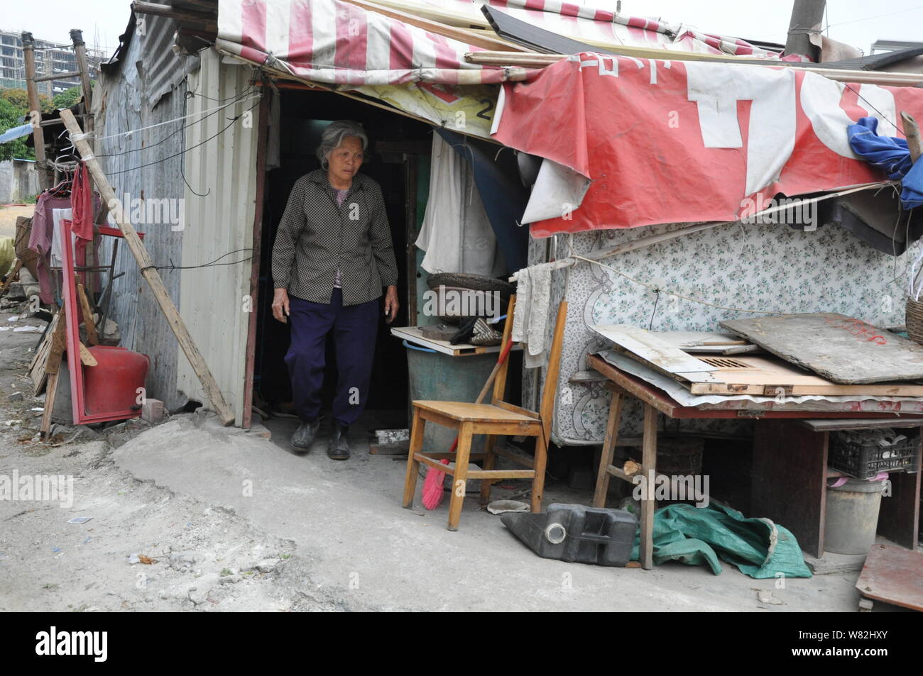 Ältere chinesische Frau Meng Yi, der neun Jahre alten Mädchen Mao Mao angenommen, dargestellt an Ihrem shanty Haus in Tangsha Stadt ist, Dongguan City, South China G Stockfoto