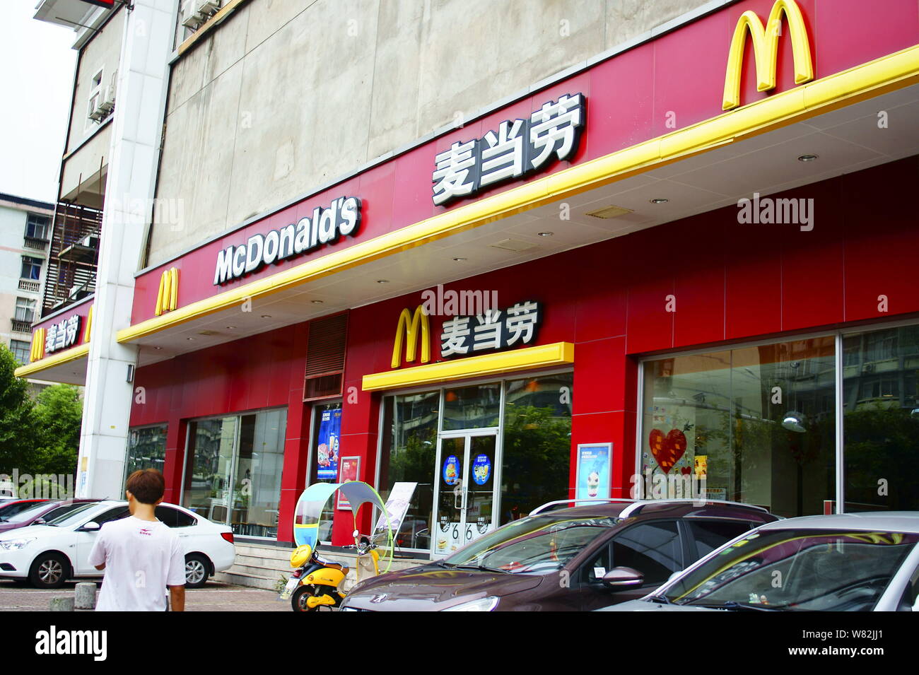 ---- Ein Fußgänger geht hinter einem Fastfood Restaurant von McDonald's in Kunshan City, Central China Provinz Hubei, 9. August 2016. Die Hong Kong Co Stockfoto